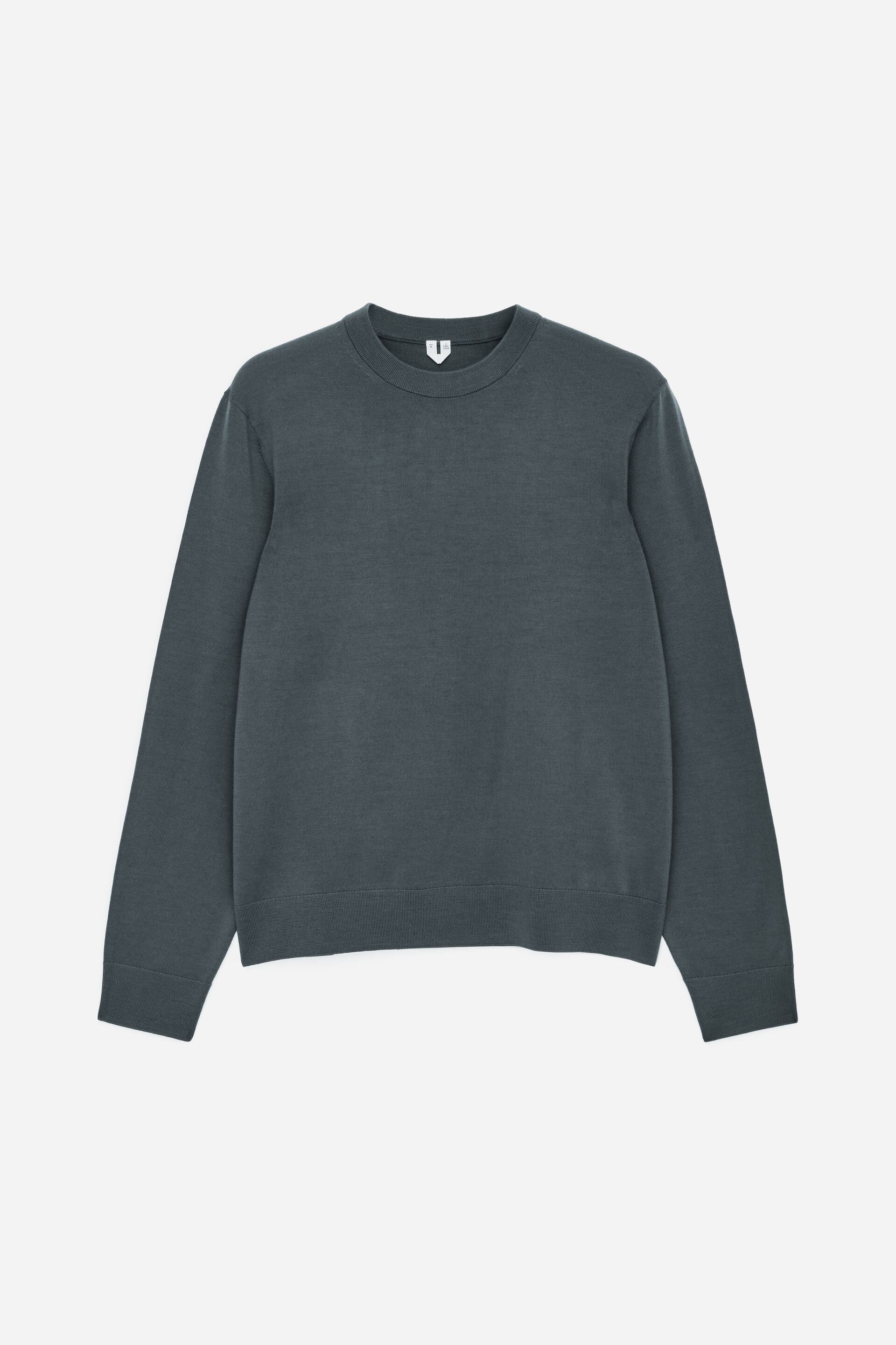 Größeres Bild anzeigen: Ein dunkelgrauer Feinstrickpullover wird von vorne gezeigt. Er verfügt über einen Rundhalsausschnitt mit geripptem Abschluss, sowie gerippte Bündchen und einen gerippten Saum.