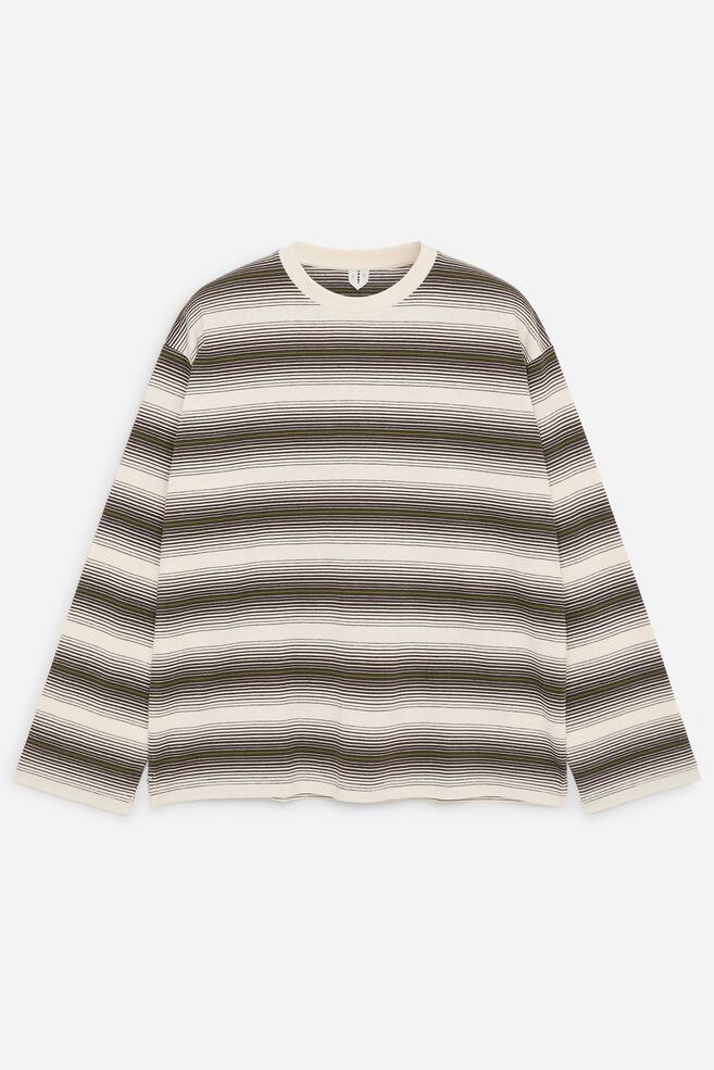 Un T-shirt Ã  manches longues est prÃ©sentÃ© de face, avec un motif horizontal de rayures teintes en fil dans des tons crÃ¨me, brun foncÃ© et vert olive. Ce haut Ã  coupe dÃ©contractÃ©e prÃ©sente un col rond cÃ´telÃ© couleur crÃ¨me, des manches longues amples et un ourlet droit. - 1