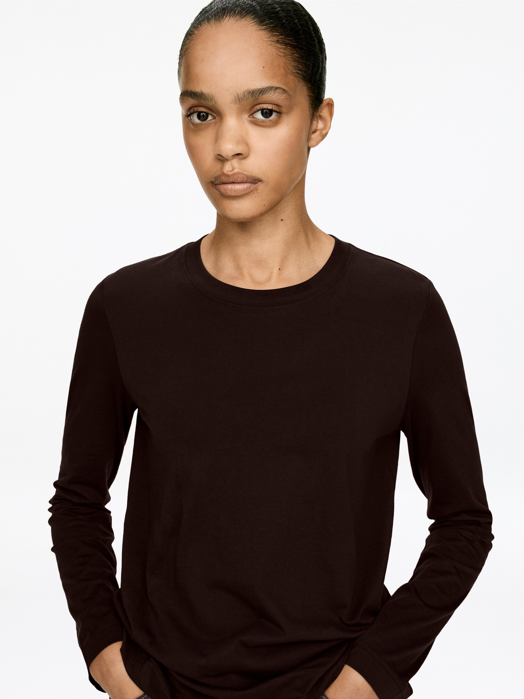 Agrandir l'image: Un t-shirt marron foncé à manches longues est doté d'un col rond et de longues manches avec des poignets simples. Il est orienté vers l'avant, montrant une coupe décontractée et une texture de tissu lisse.