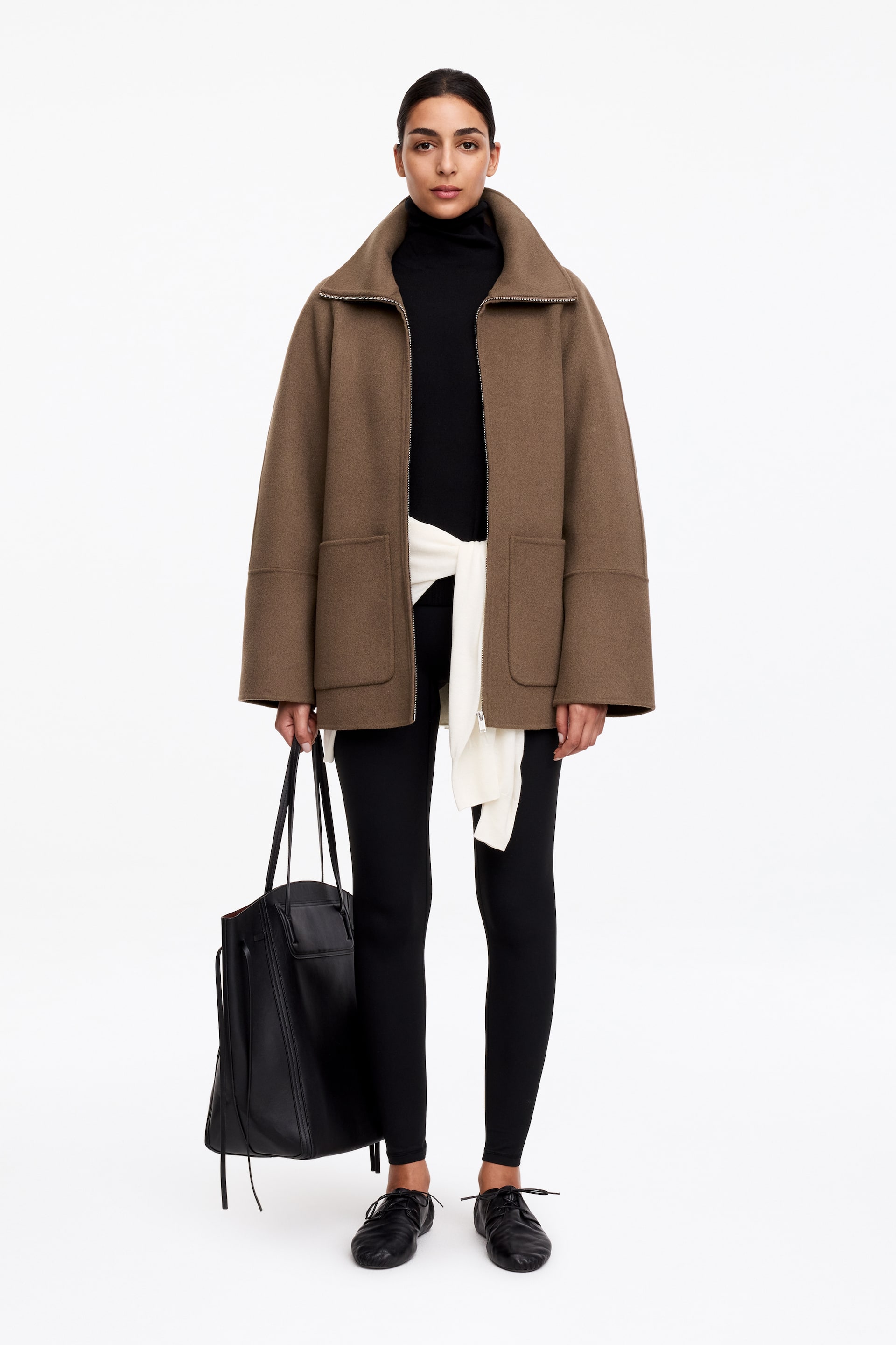 View larger image: A brown jacket is facing front, showcasing an oversized, boxy fit with a wide stand-up collar, a partially open front zip fastening, and two large rectangular patch pockets.