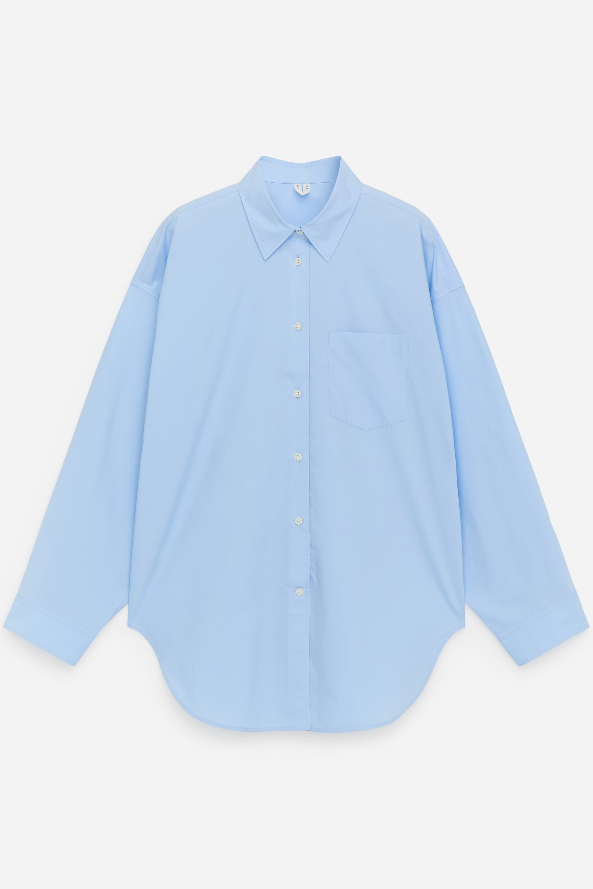 Ver imagen más grande: Una camisa azul claro muestra su PARTE DELANTERA, con un cuello en punta, una tapeta completa de botones con botones blancos y un bolsillo de parche en el pecho izquierdo. Las mangas largas se extienden hasta unos puños simples, y el dobladillo es curvado.