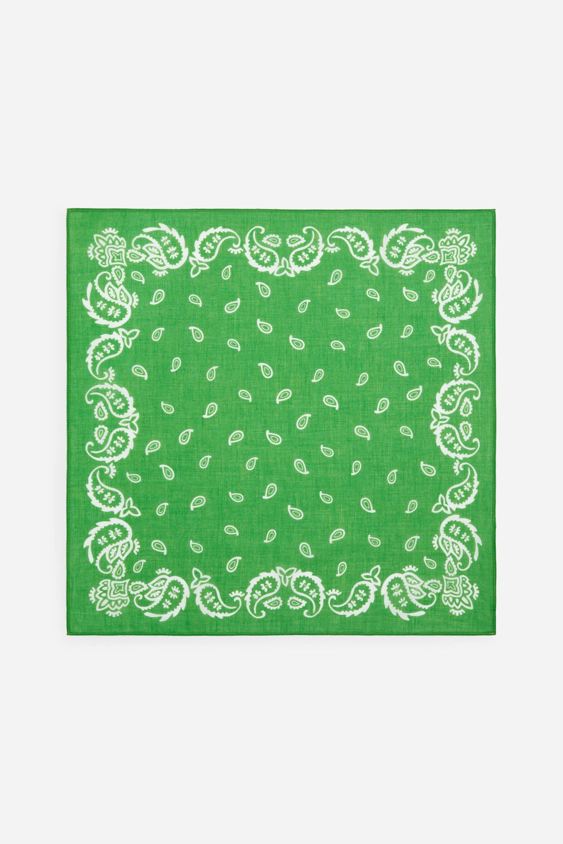Näytä suurempi kuva: Vihreä bandana on asetettu tasaisesti esille, ja siinä on valkoinen paisley-kuvio. Suuremmat paisley-kuviot muodostavat reunuksen, ja pienemmät yksittäiset paisleyn muodot levittäytyvät keskiosaan.
