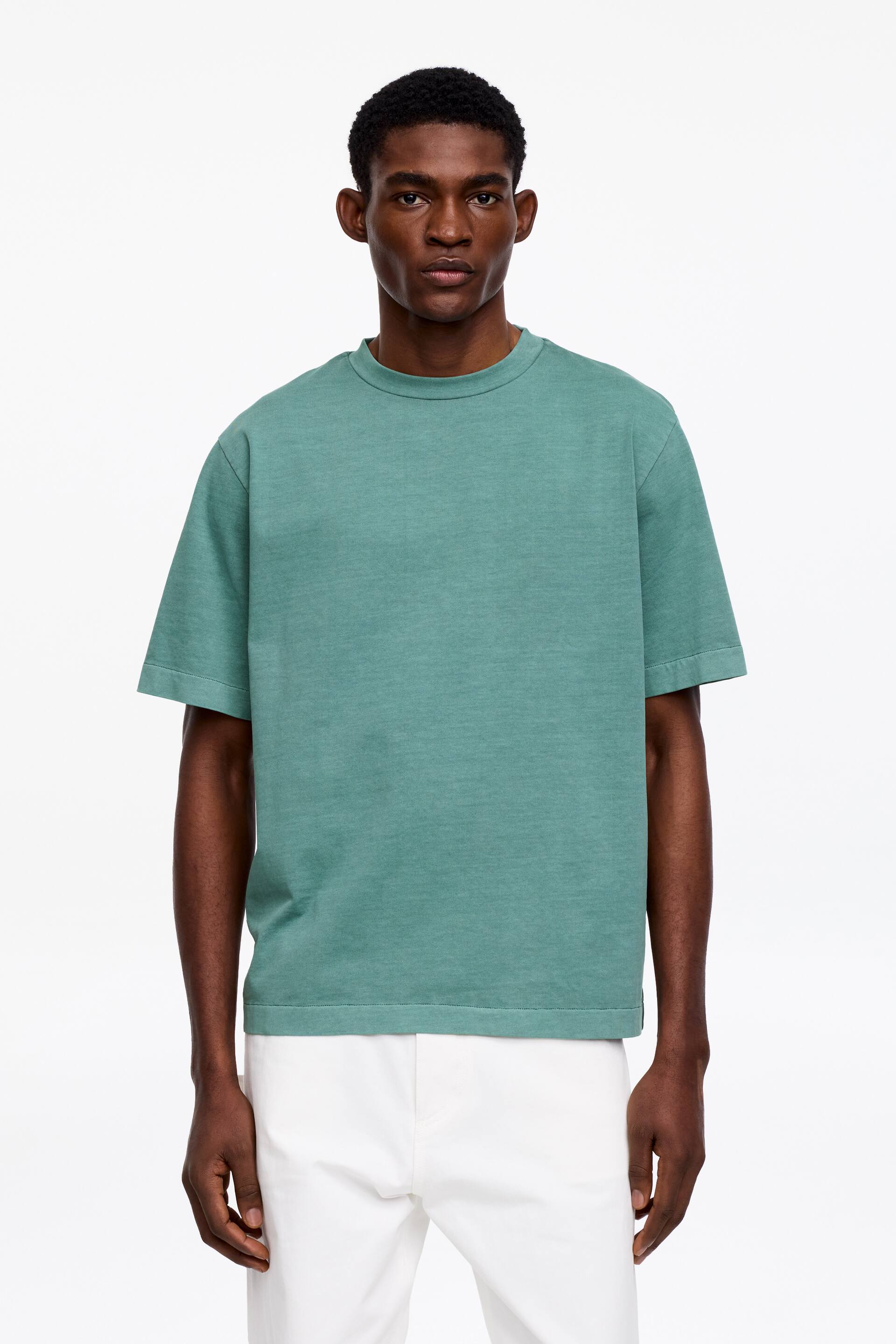 Ver imagen más grande: Una camiseta de algodón verde azulado, diseñada para un ajuste holgado y con cuello redondo acanalado, está siendo llevada por el modelo.