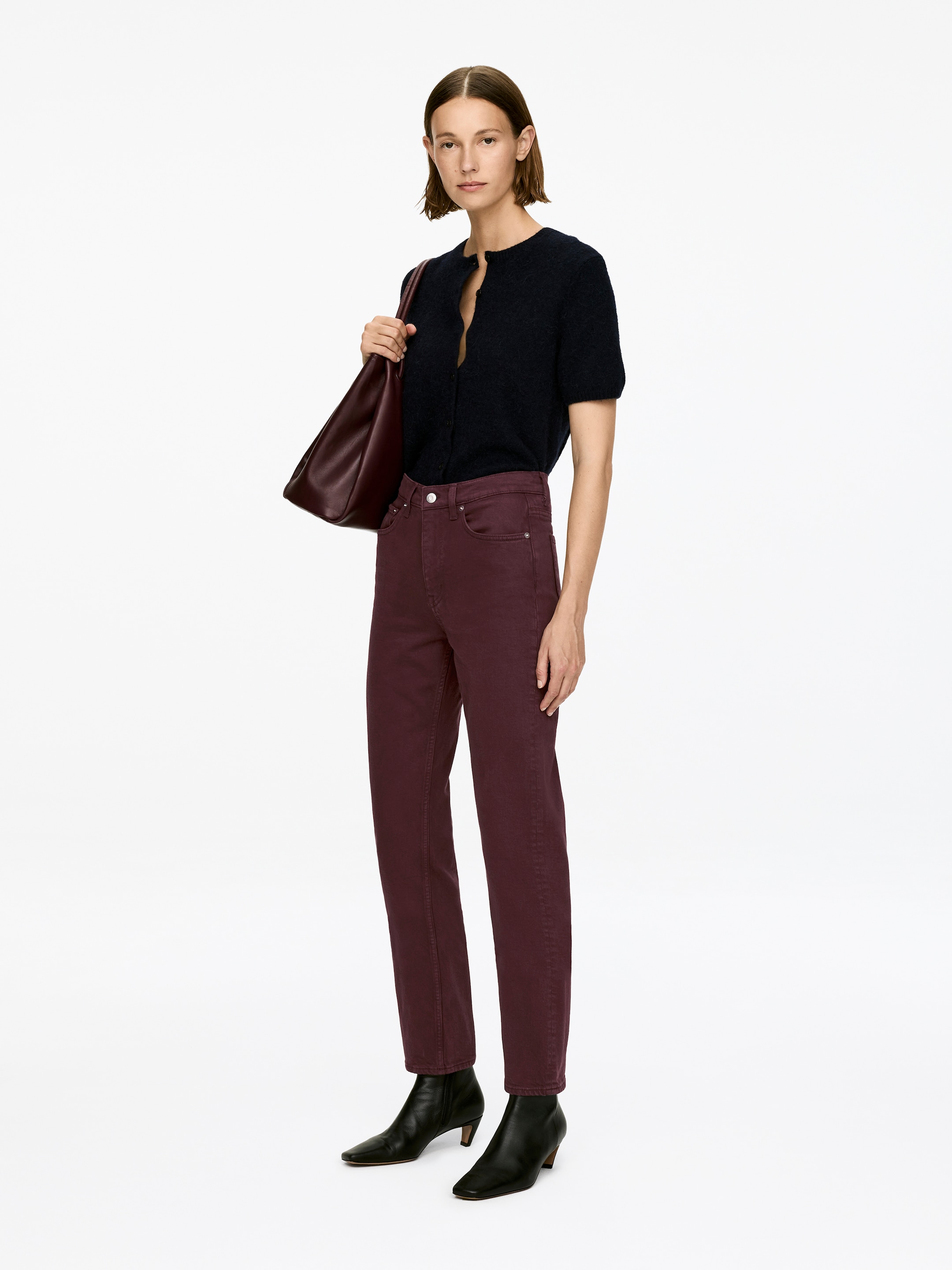 View larger image: JADE CROPPED jeans, in a deep red hue, are being worn by the model. The jeans are displaying a mid-rise waist, a visible zip fly, a slim fit, and tapered, cropped legs, which are being paired with black ankle boots.