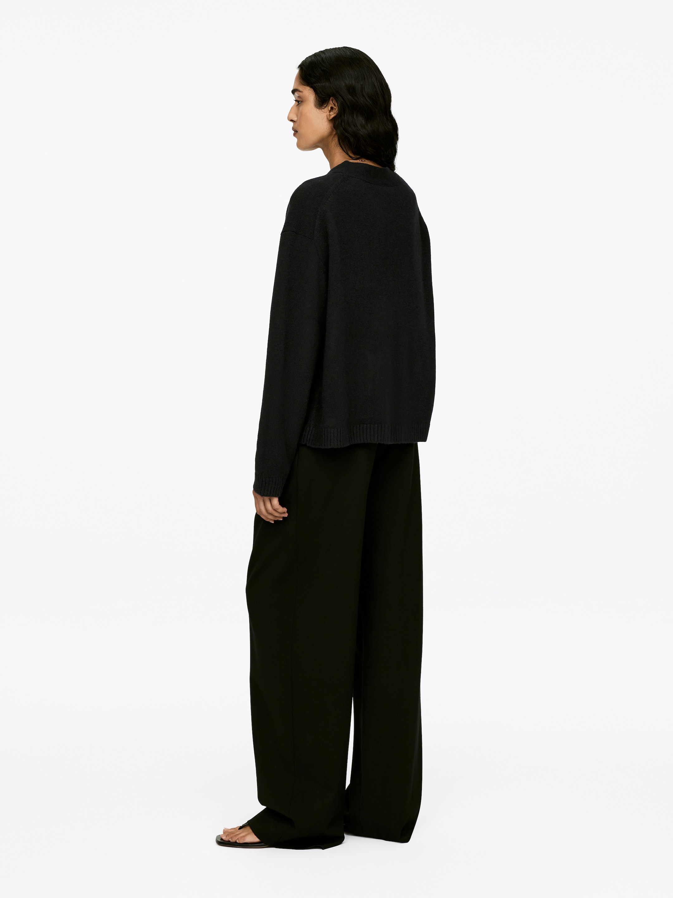 View larger image: A dark, long-sleeved cardigan with a loose fit and rib-knitted trims is being worn by the model.