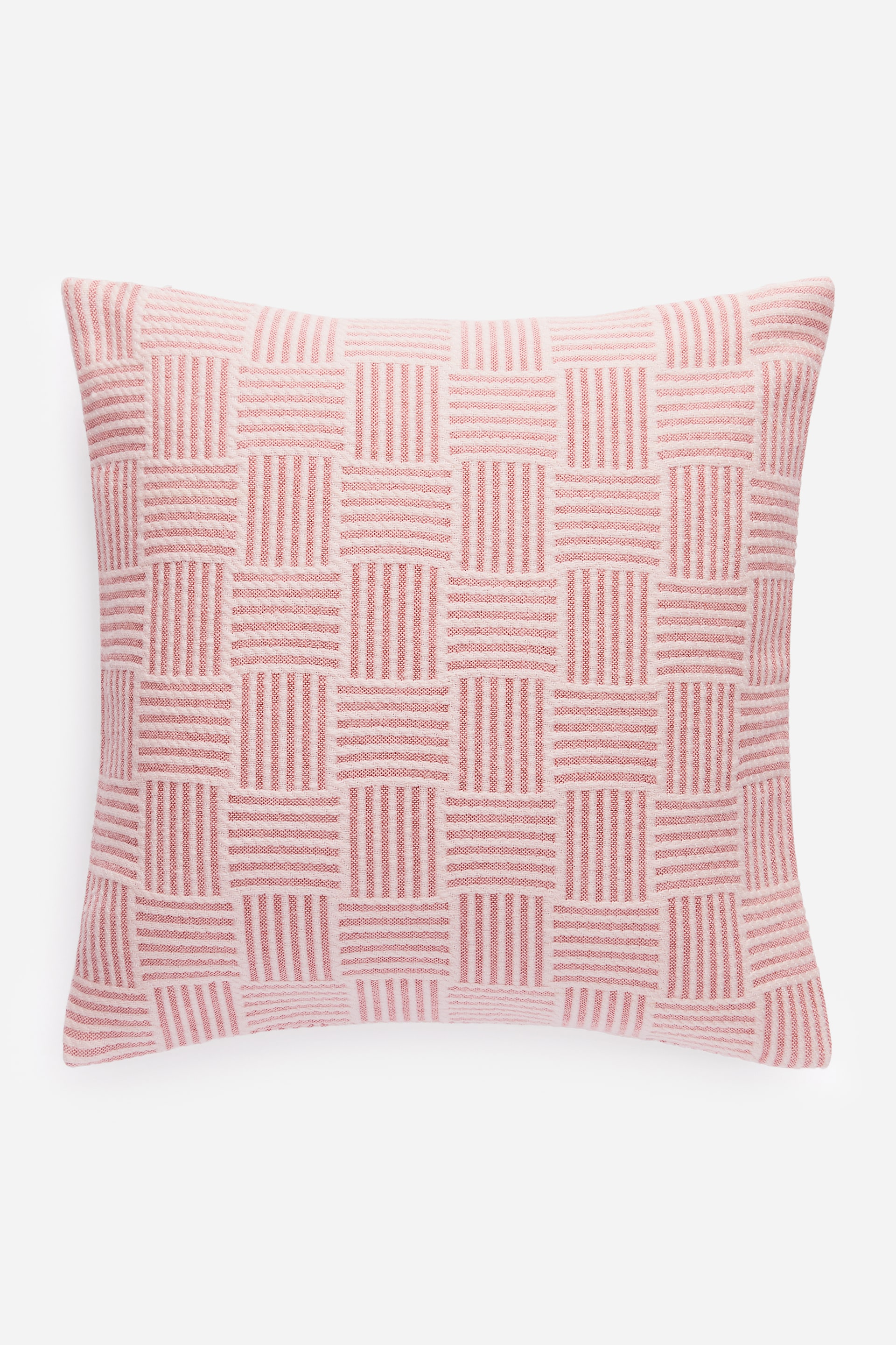 Visualizza immagine più grande: Una copertura per cuscino quadrata mostra la parte anteriore, caratterizzata da un motivo geometrico jacquard intrecciato con strisce orizzontali e verticali alternanti in rosa e bianco sporco.