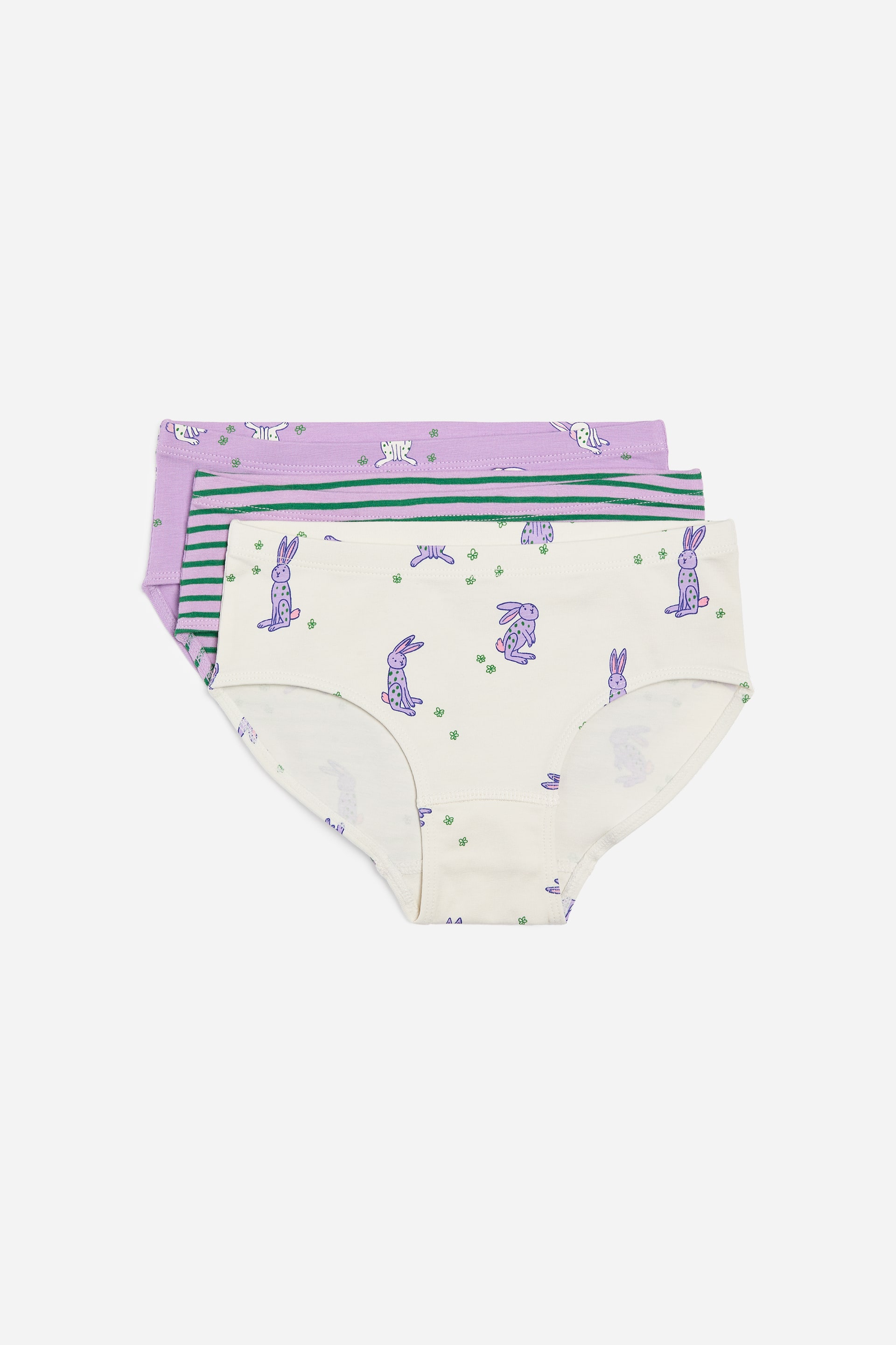Agrandir l'image: Des slips doux en coton, disponibles dans un mélange de couleurs unies et de versions à motifs, sont empilés, présentant leurs faces avant. Le slip du bas arbore une base crème avec des motifs de lapins violets, celui du milieu présente une base violette claire avec des rayures horizontales vertes, et le slip du haut montre une base violette claire avec des motifs de lapins blancs.