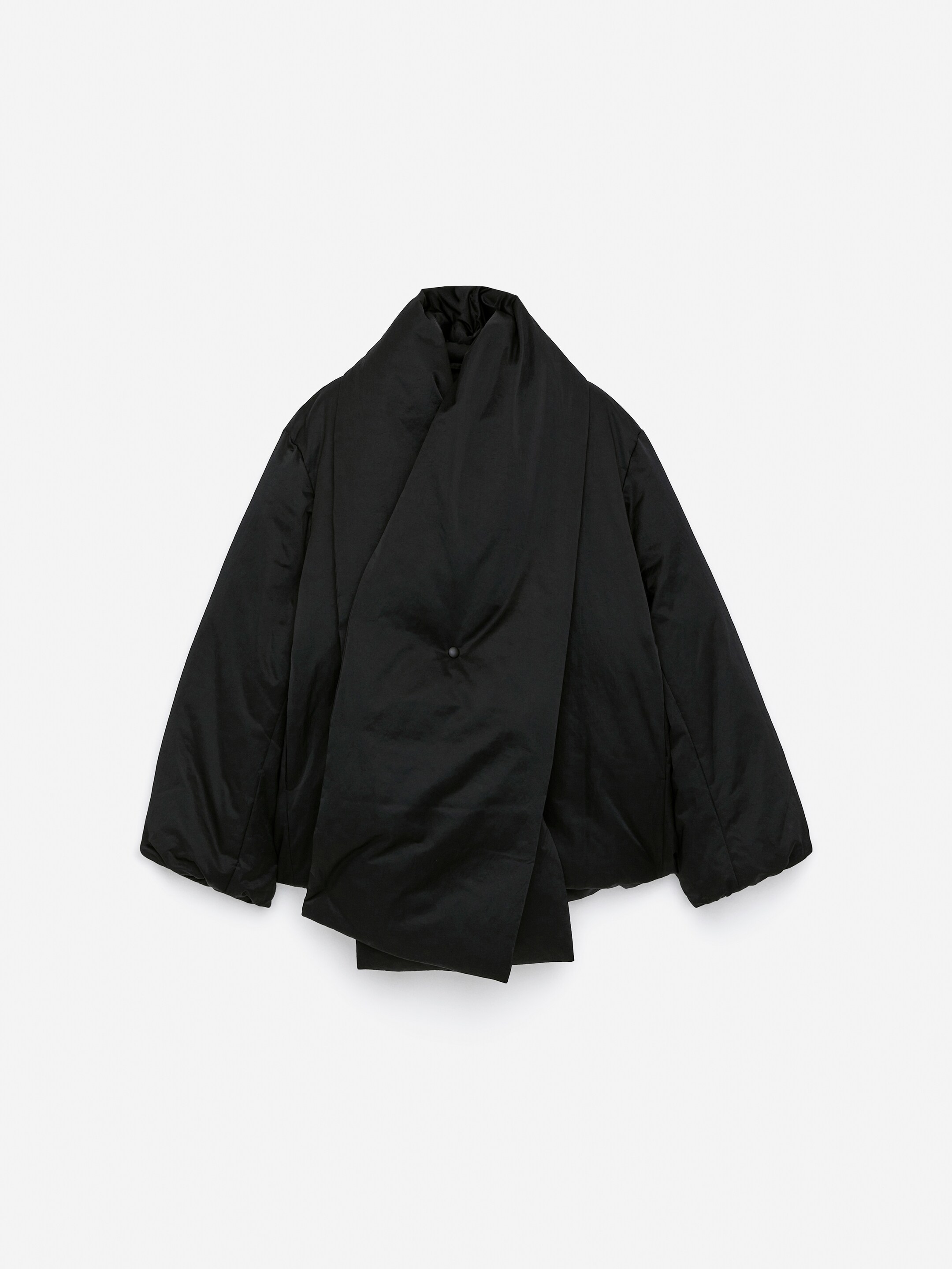 Vis større bilde: Den svarte Upcycled Down Scarf Jacket er presentert forfra og lagt flatt, med et bredt, polstret skjerfelement som krysser foran. Dette elementet er sikret med en enkelt svart knapp og danner en høy stående krage, mens brede, polstrede ermer strekker seg fra sidene.