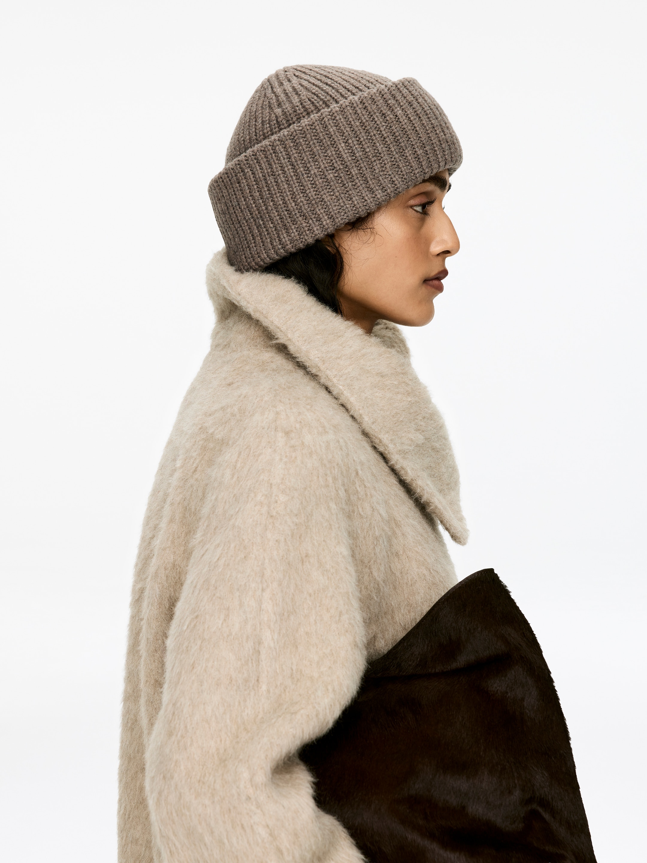 View larger image: A taupe double-fold wool beanie, knitted in a half cardigan stitch, is being worn on the model's head.