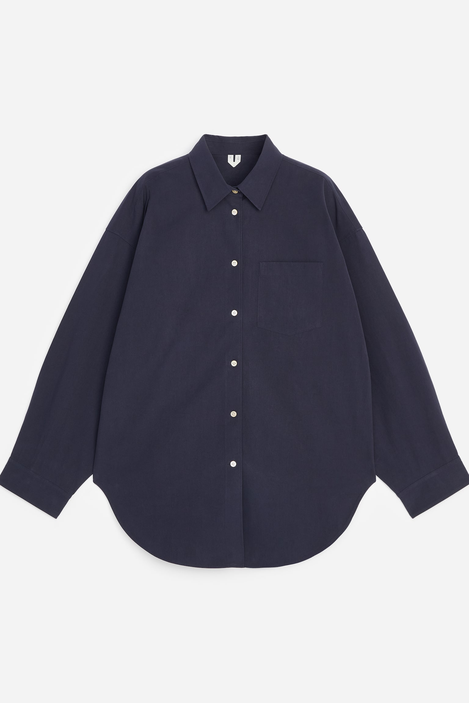 Een oversized donkerblauw hemd vervaardigd uit zware pima-katoen wordt van voren gepresenteerd. Het heeft vleermuisvormige mouwen, een enkele borstzak, een puntige kraag en een knoopsluiting aan de voorkant met lichte knopen, en is afgewerkt met een gebogen zoom. - 1
