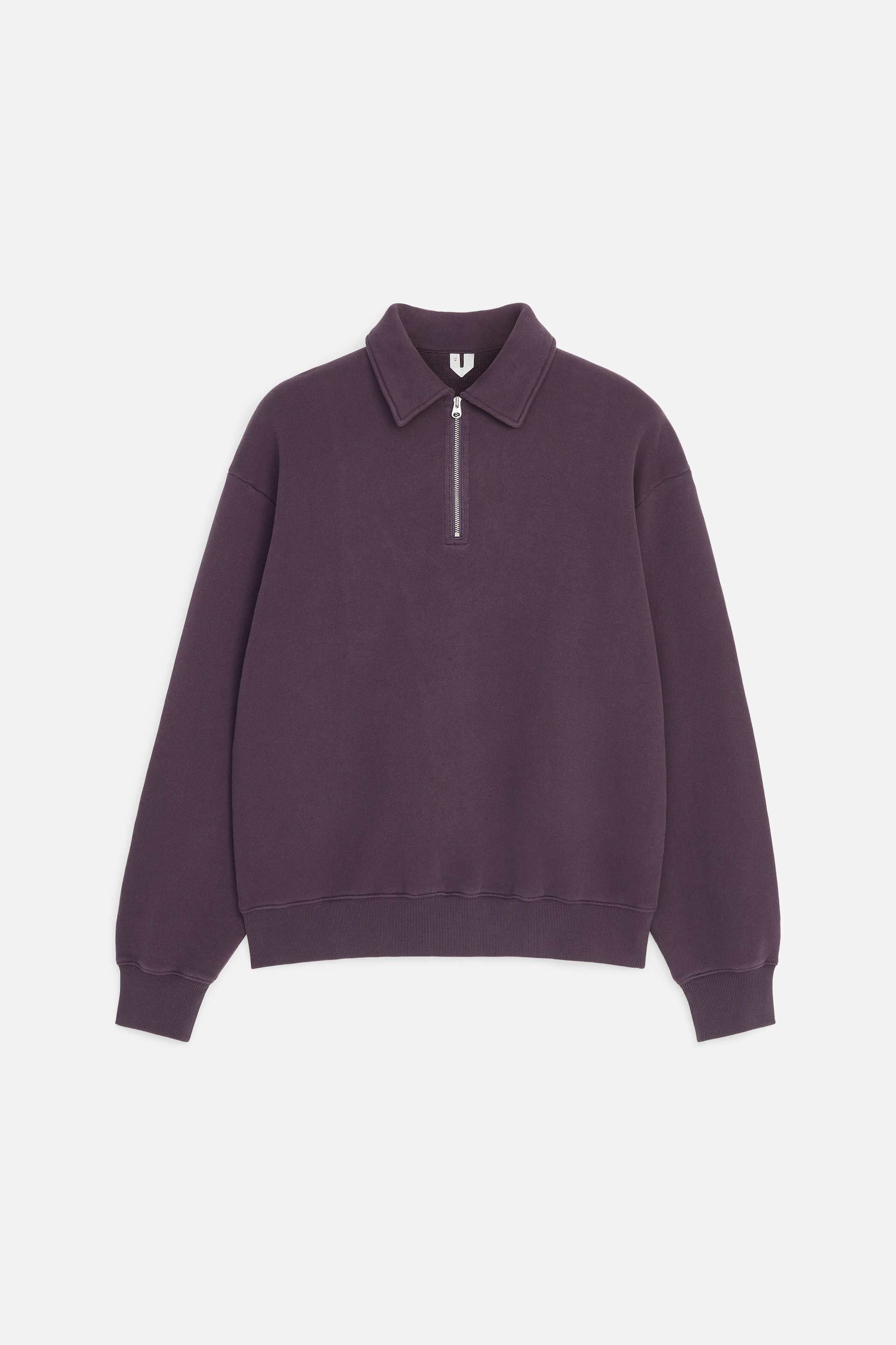 Grotere afbeelding bekijken: Een donkerpaarse sweatshirt is van voren te zien en heeft een klassieke kraag en een zilverkleurige metalen half-zip-sluiting. Het kledingstuk heeft verlaagde schouders, lange mouwen met geribde boorden en een bijpassende geribde zoom.