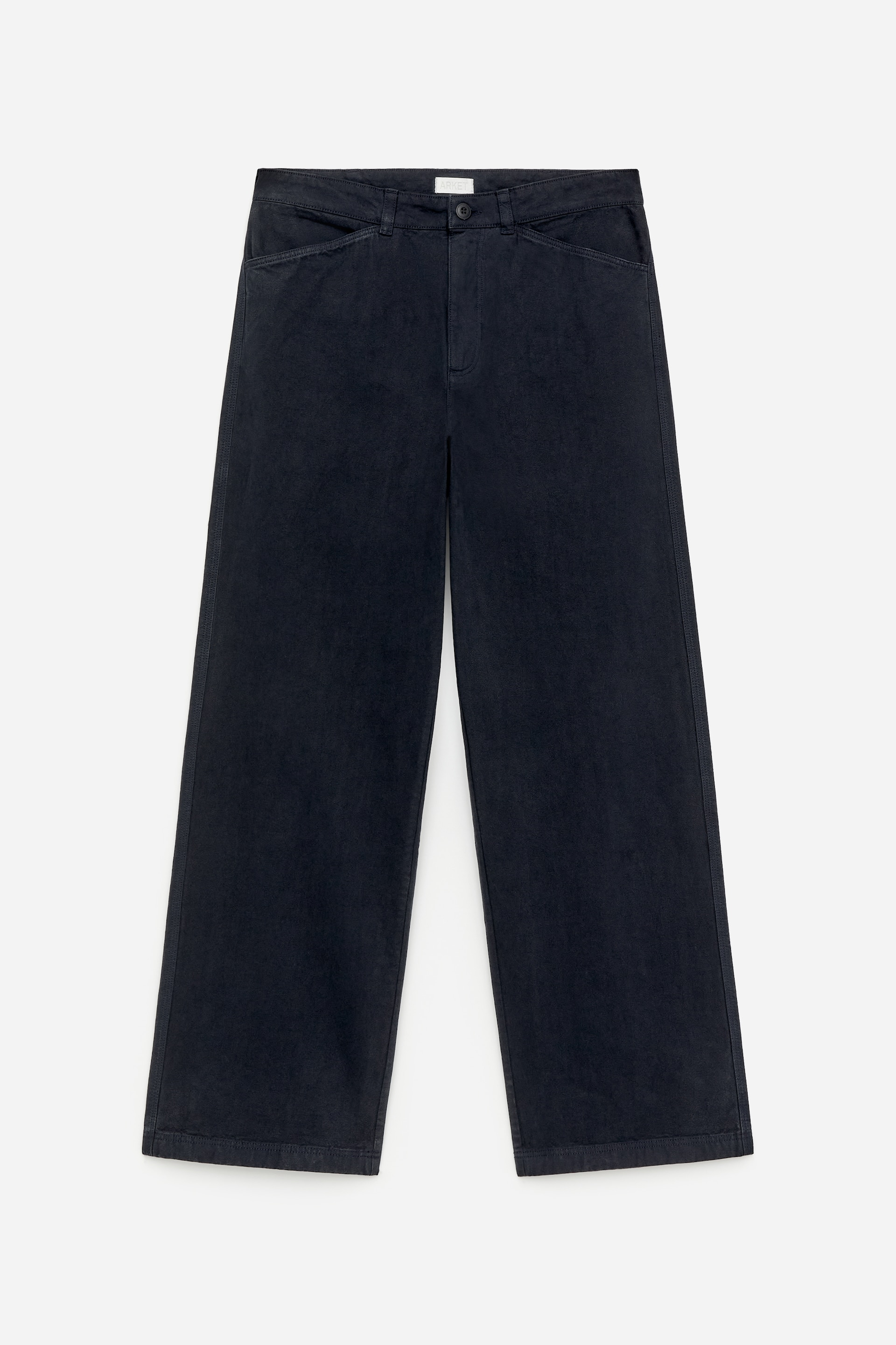 Grotere afbeelding bekijken: Zwarte werkbroek-geïnspireerde broek, vervaardigd van katoenen canvas, wordt van de voorkant getoond. Ze hebben een middelhoge taille, een ontspannen pasvorm en twee schuine voorzakken, met een enkele knoopsluiting zichtbaar bij de taille.