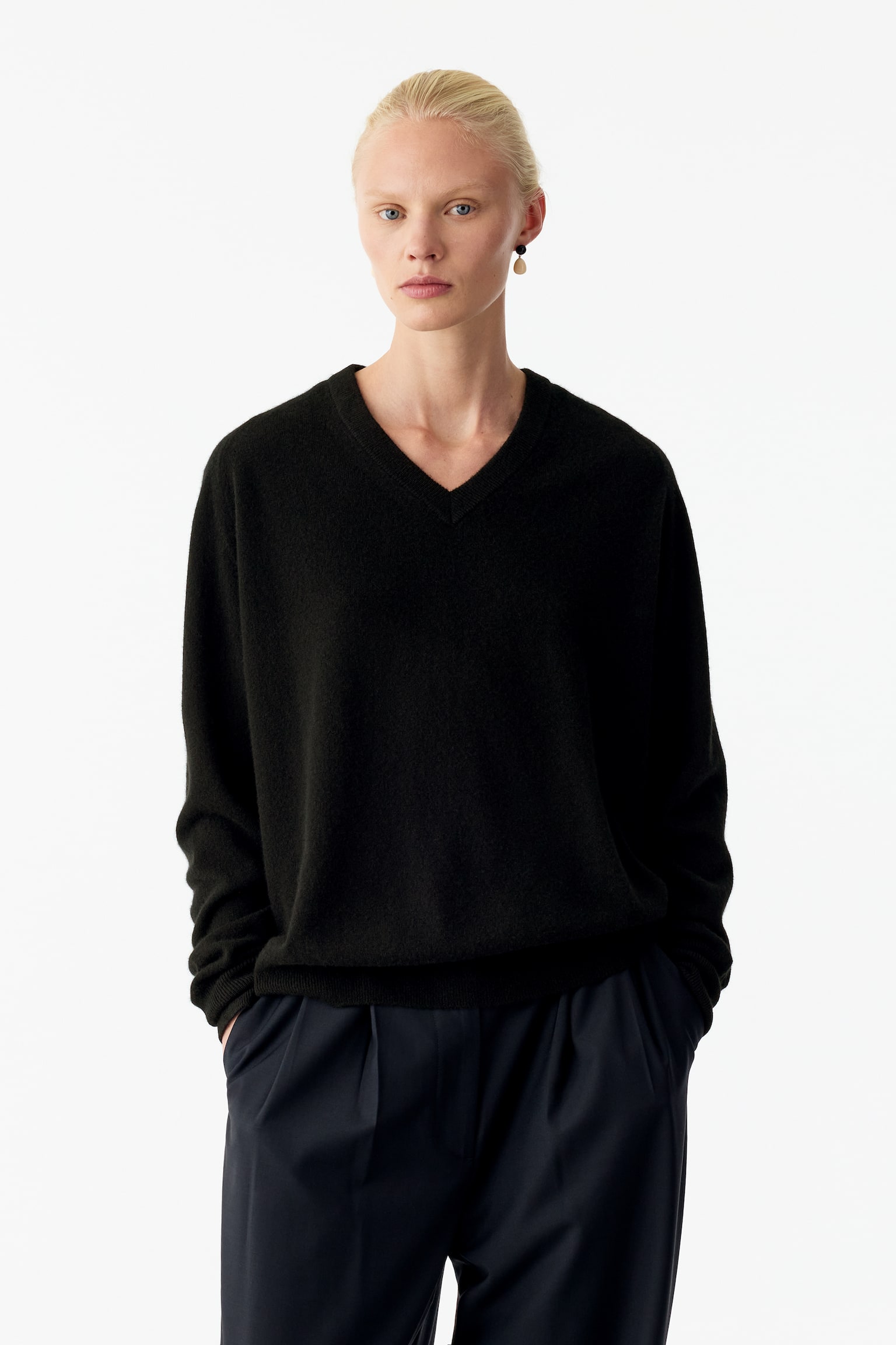 Ein schwarzer Relaxed-Cashmere-Pullover mit V-Ausschnitt wird von vorne gezeigt und zeichnet sich durch eine lockere Silhouette, einen gerippten V-Ausschnitt sowie lange Ãrmel mit gerippten Bündchen und einem passenden gerippten Saum aus. - 1