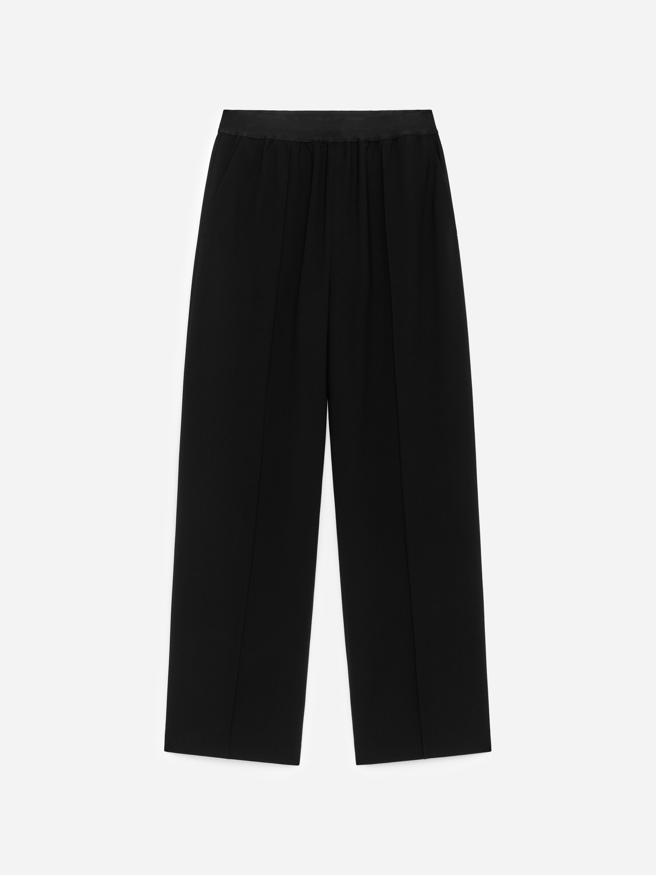 Agrandir l'image: Pantalon large noir affichant une vue de face, avec une ceinture à finition satinée et lisse. Ils présentent des plis verticaux pressés le long de l'avant de chaque jambe et des poches latérales discrètes.
