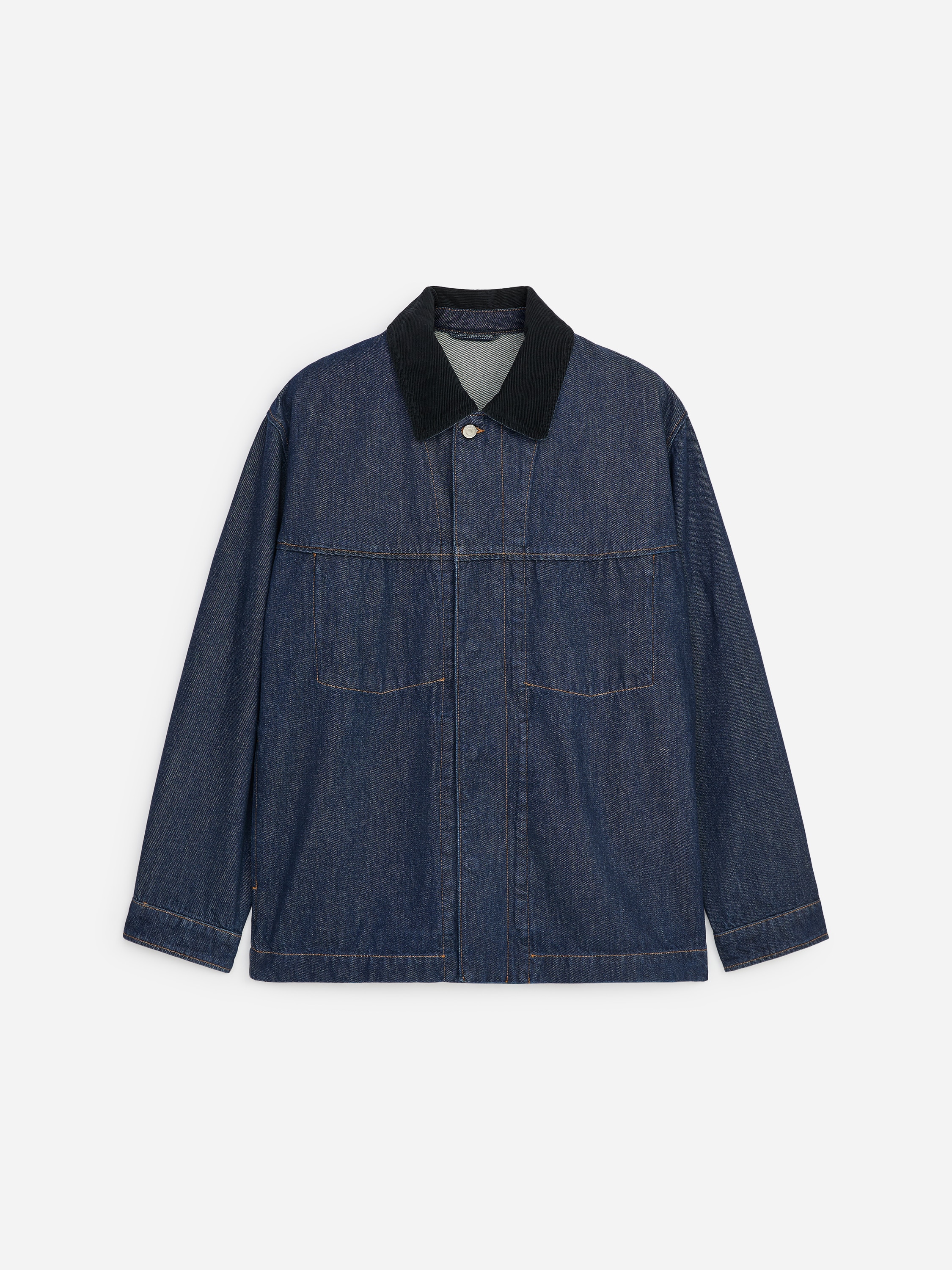 A dark blue, relaxed-fit denim railway jacket featuring a black corduroy collar and visible stitching from internal pockets is being worn by the model. The jacket is styled open over a blue-and-white striped T-shirt and beige trousers.