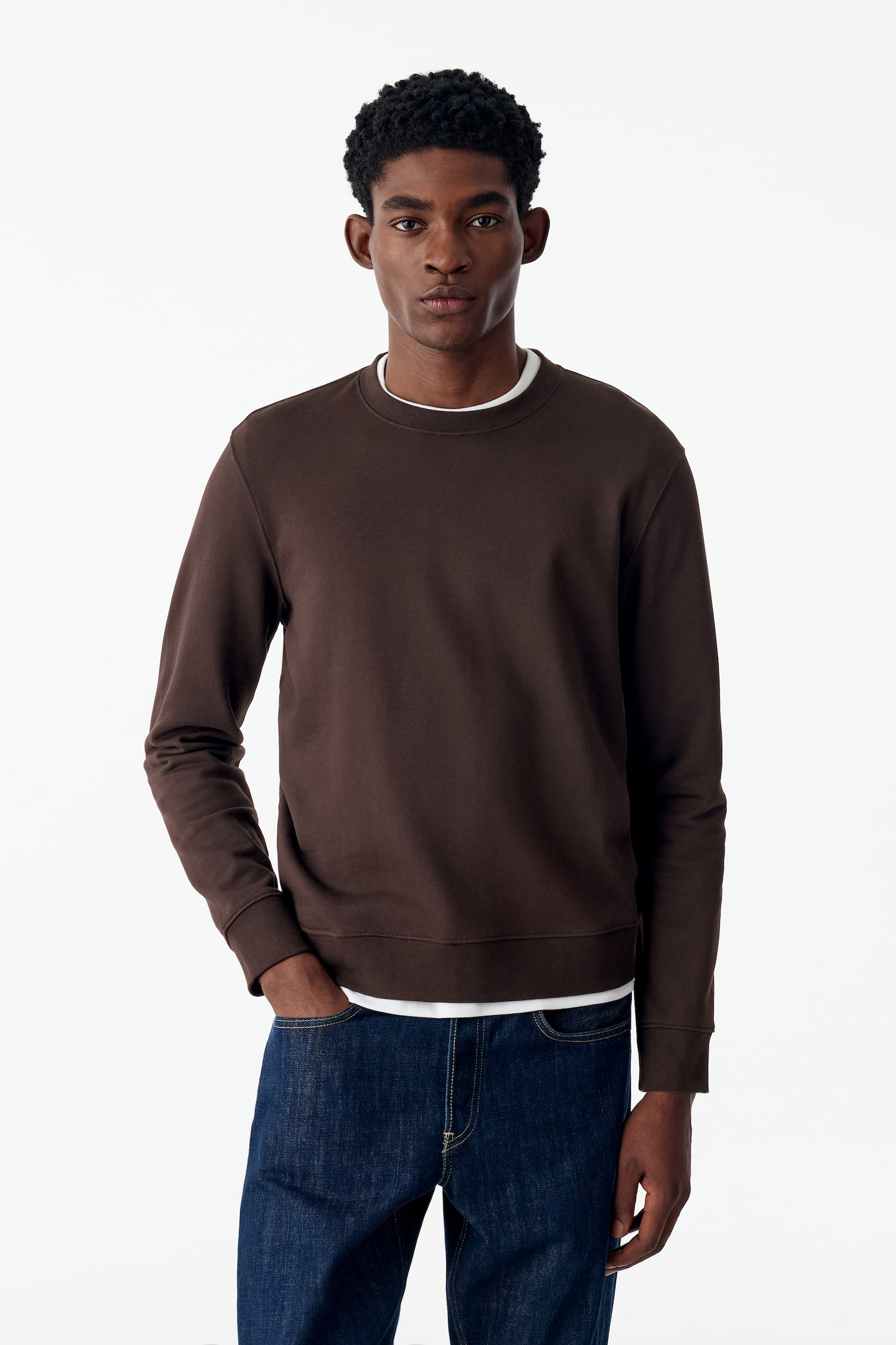 Een donkerbruine sweatshirt met ronde hals is van voren afgebeeld en toont een regular-fit pasvorm. De sweatshirt heeft lange mouwen met geribde boorden, een geribde ronde hals en een bijpassende geribde zoom. - 1