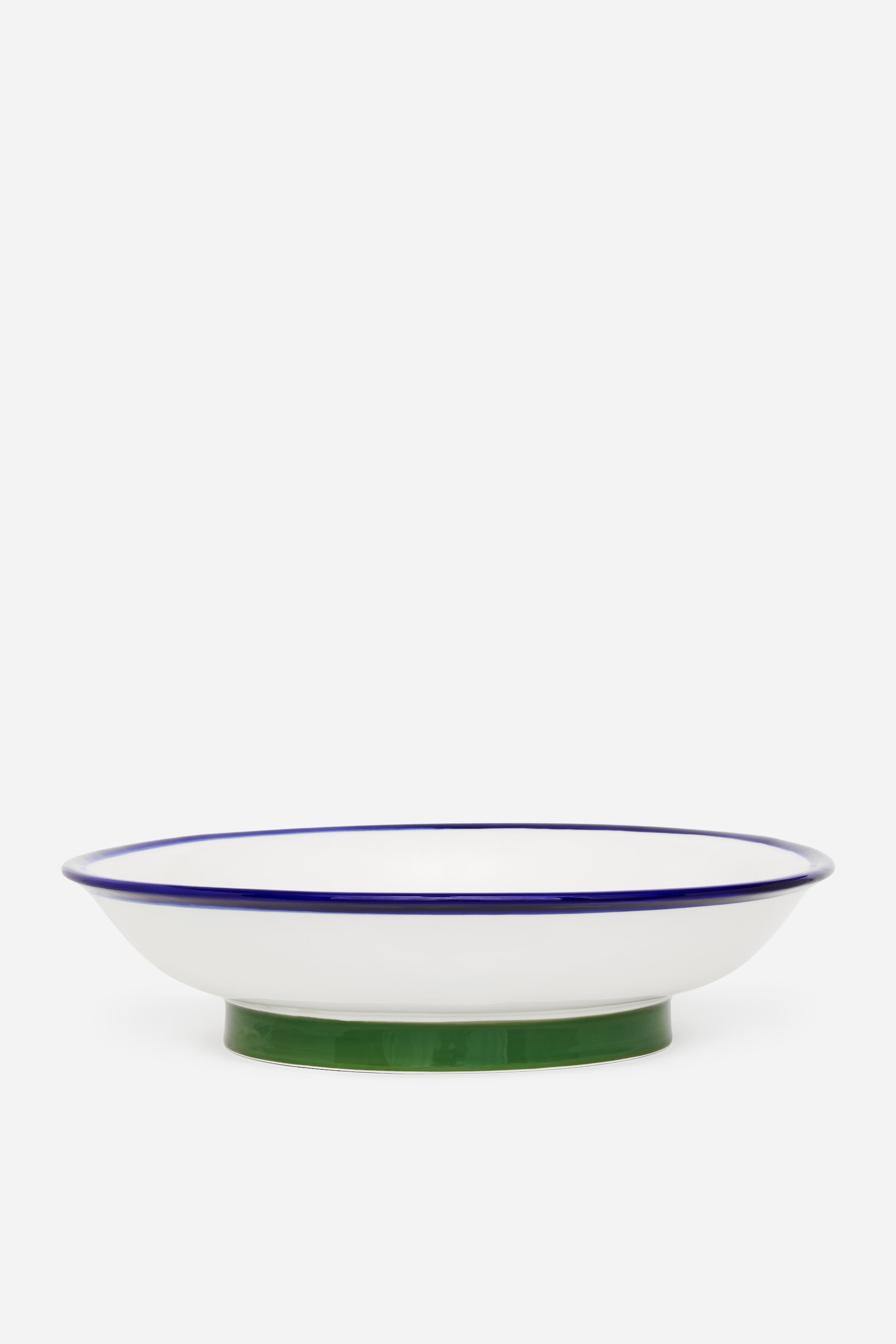 Προβολή μεγαλύτερης εικόνας: Ένα ρηχό λευκό μπολ παρουσιάζεται από μπροστά, διαθέτοντας μια σκούρα μπλε λωρίδα κατά μήκος του χείλους του και μια συμπαγή πράσινη, κυλινδρική βάση.
