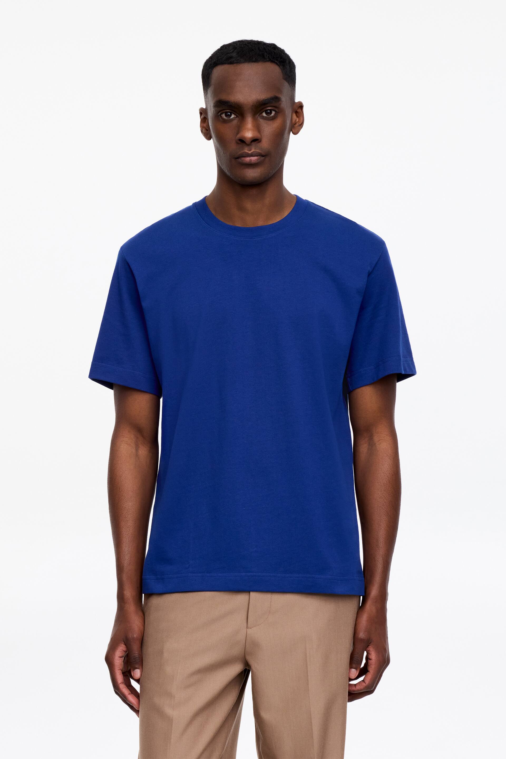 Visa större bild: En blå t-shirt med rund hals, korta ärmar och rak fåll. Den har en normal passform, sedd framifrån.