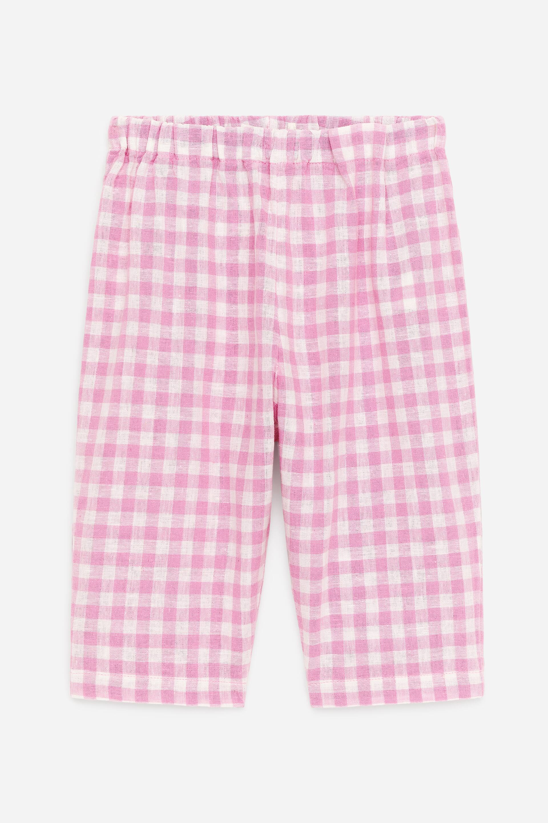 Vezi imaginea mai mare: Pantaloni cu croială lejeră, confecționați dintr-un amestec moale de in și bumbac, sunt prezentați din față, evidențiind un model cu carouri gingham roz și alb. Aceștia dispun de o talie elastică, ajustabilă și o croială dreaptă a piciorului.