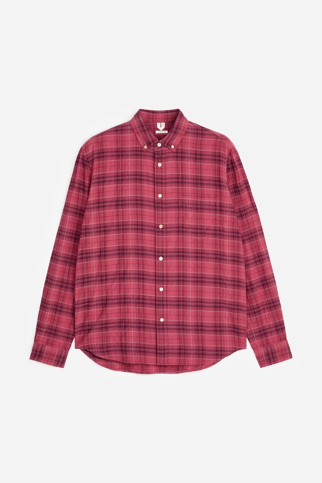Ein langärmeliges Hemd zeigt seine Vorderseite mit einem rot- und kastanienbraun karierten Muster. Es ist mit einem Button-Down-Kragen, einer durchgehenden Knopfleiste mit hellen Knöpfen, einer einzelnen Brusttasche auf der linken Seite, langen Ärmeln mit geknöpften Manschetten und einem abgerundeten Saum gestaltet. - 1