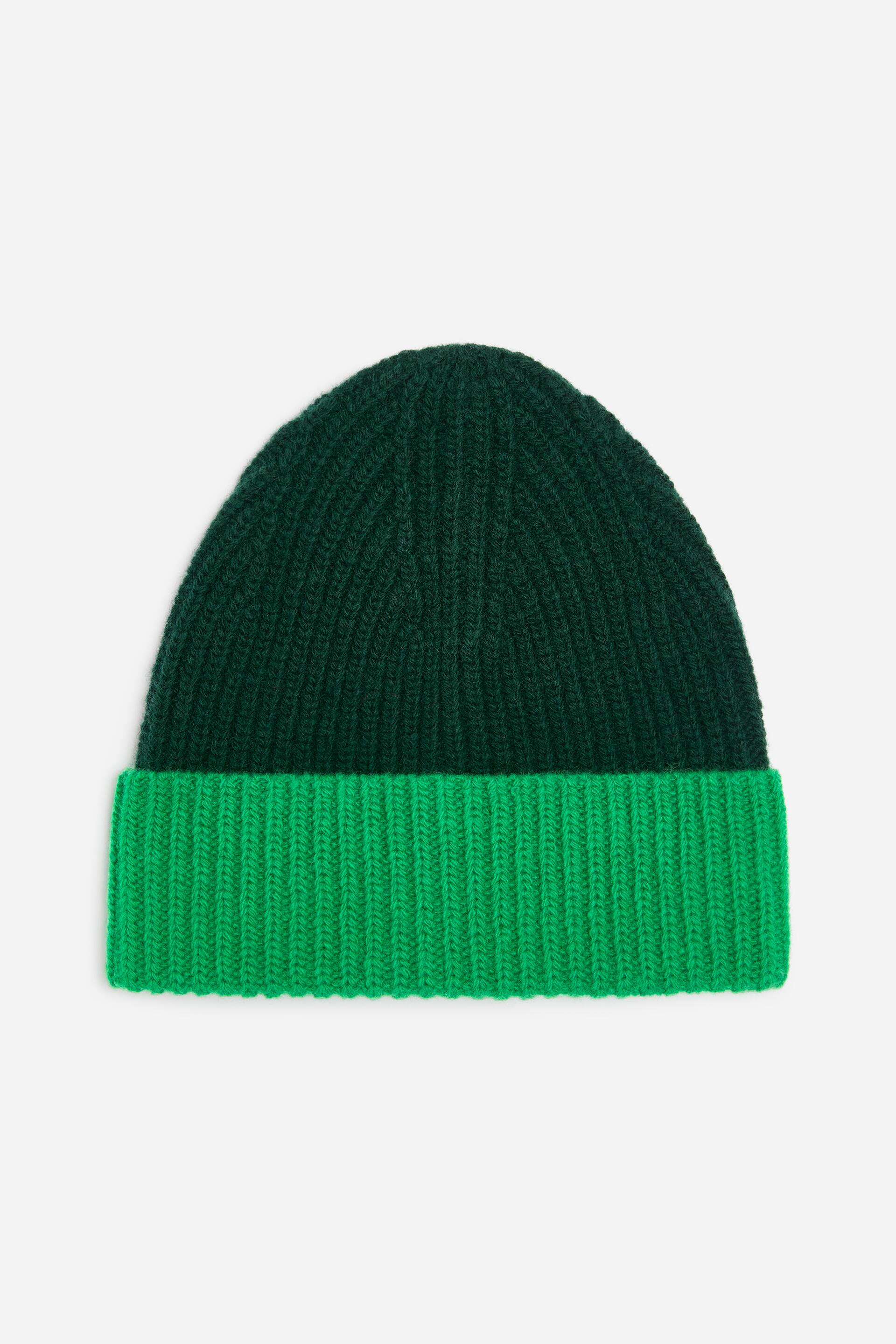 View larger image: A rib-knit beanie is shown from the front in a chunky style, featuring a dark green upper section and a bright green fold-up cuff.