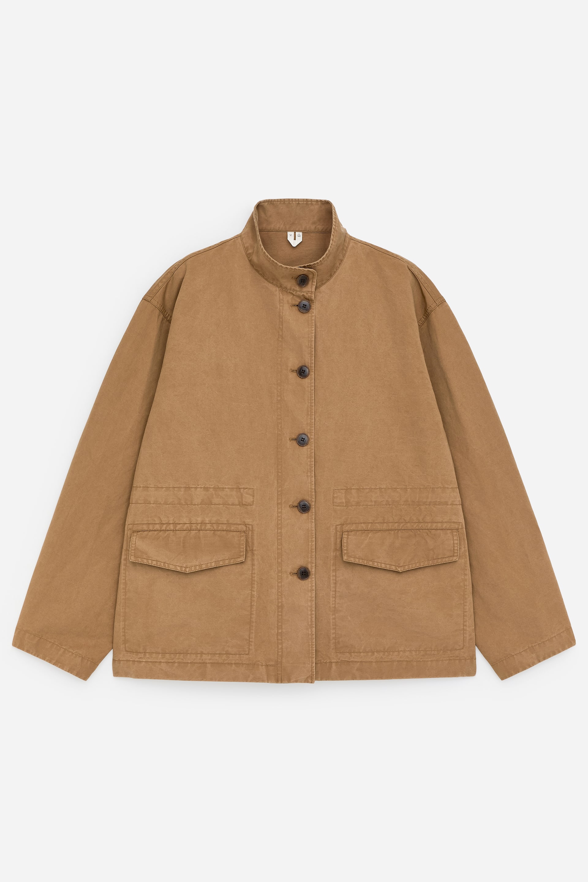 Agrandir l'image: Une surchemise décontractée couleur tan présente sa vue de FACE, avec un col officier et une fermeture frontale complète à boutons foncés marron. Deux grandes poches plaquées à rabat apparaissent sur le bas avant.