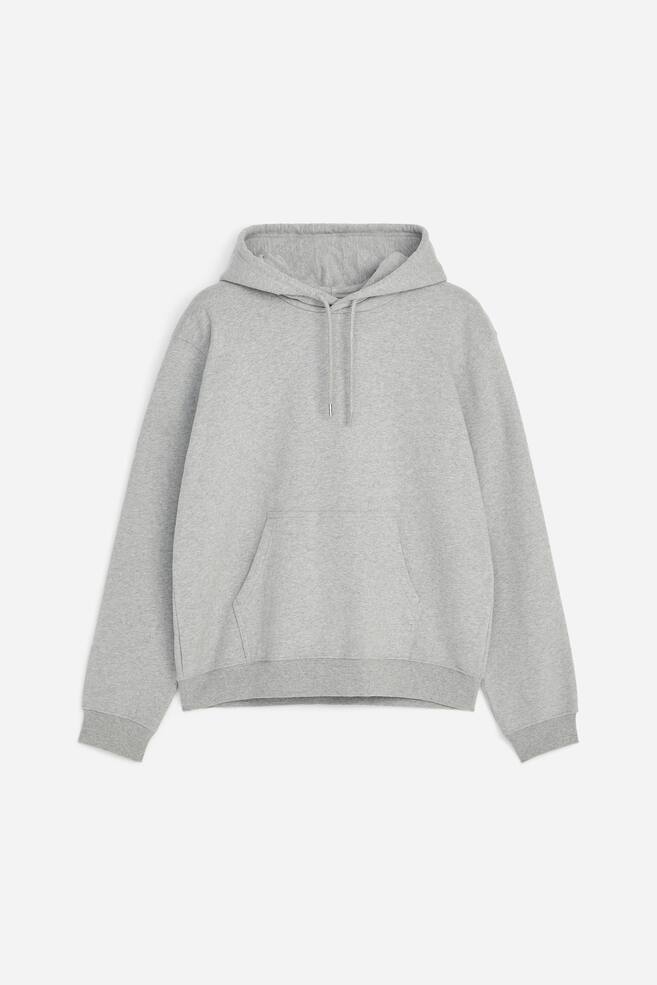 A light grey hooded sweatshirt is shown from the front, featuring adjustable drawstring cords at the hood and a front kangaroo pocket. The garment displays a regular fit with ribbed cuffs and a matching ribbed hem. - 1