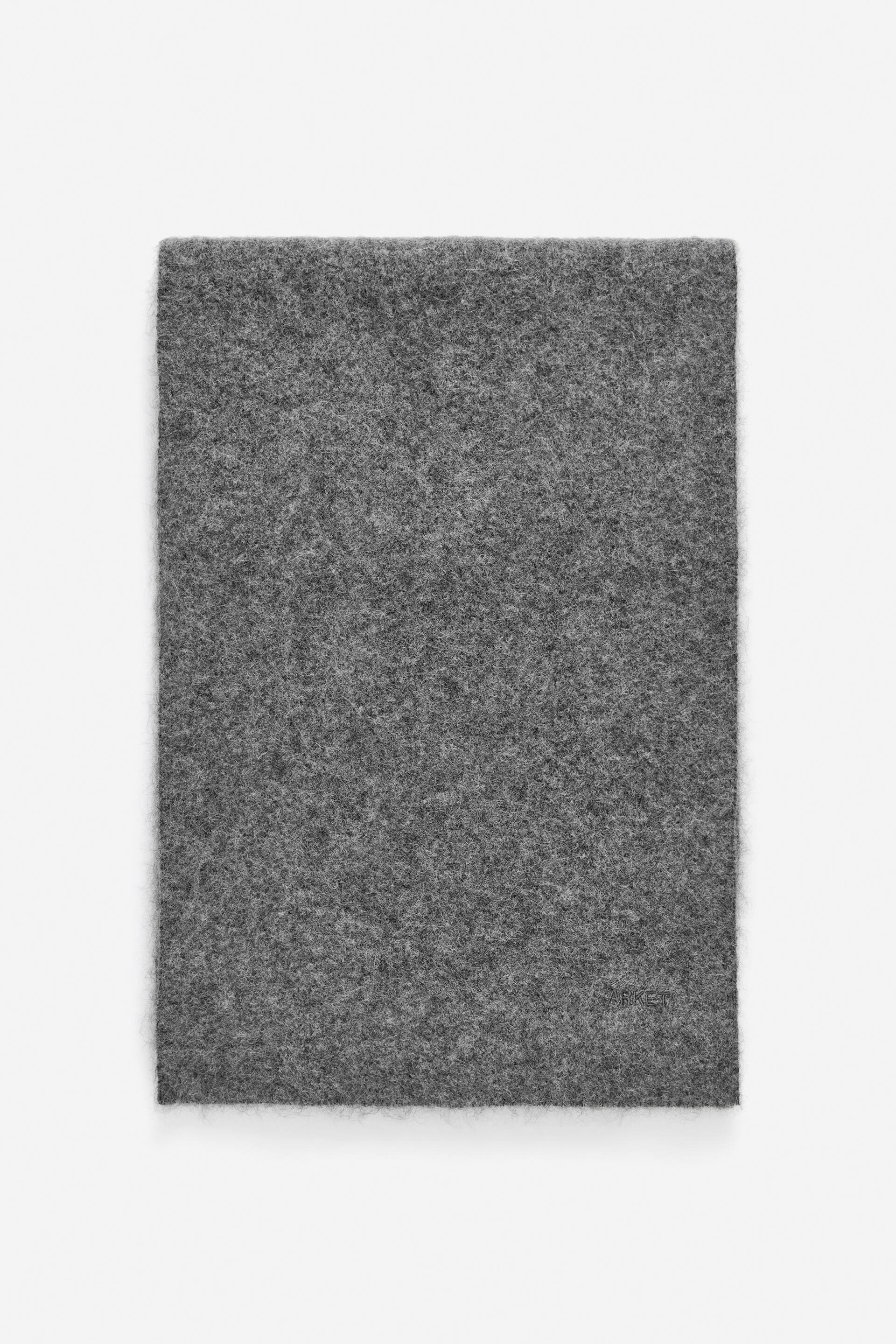 Vis større bilde: Et rektangulært stykke grått filtstoff ligger flatt. Det har en marmorert tekstur med synlige fibre og litt lodne kanter.