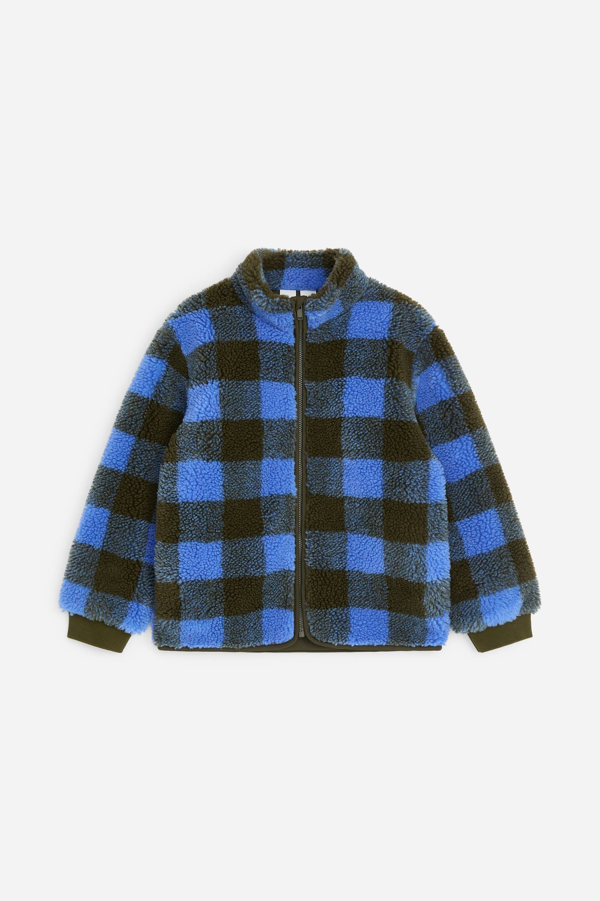 Visualizza l'immagine ingrandita: Una giacca in pile presenta un motivo a quadri blu e verde scuro in stile buffalo, vista dal davanti. È caratterizzata da un colletto alto, una chiusura a zip integrale e polsini e orlo a coste, offrendo una vestibilità rilassata.