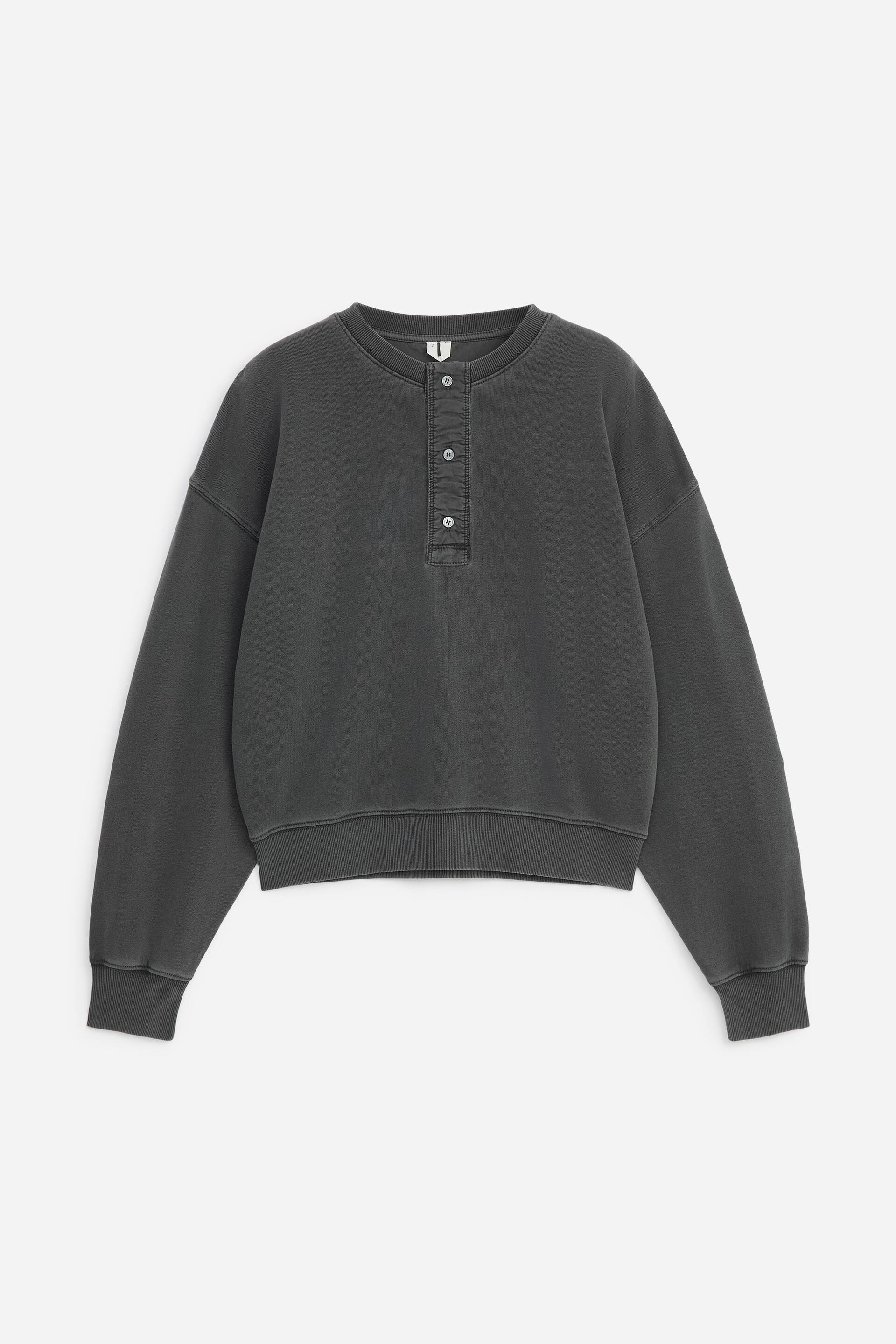 Grösseres Bild ansehen: Von vorne präsentiert, zeigt dieses dunkelgraue Henley-Sweatshirt eine lockere Passform mit überschnittenen Schultern und einer verwaschenen Vintage-Waschung. Es verfügt über eine Vier-Knopf-Frontblende, einen gerippten Rundhalsausschnitt, gerippte Ärmelbündchen und einen passenden gerippten Saum.
