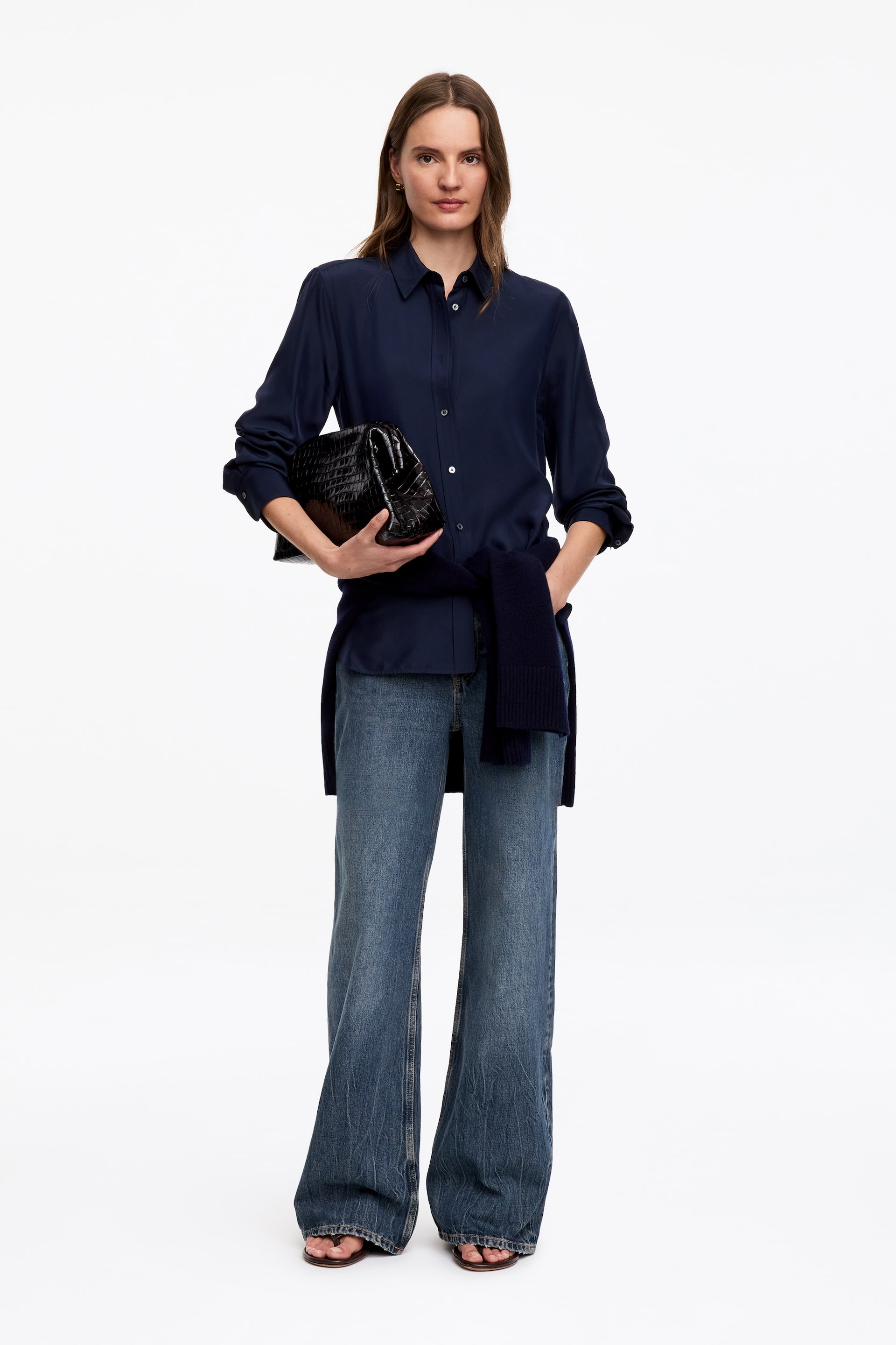 Größeres Bild ansehen: Die ELM-Jeans werden vom Model getragen und zeichnen sich durch einen blauen Denim-Stoff mit niedrigem Bund, weitem Schnitt und ausgestellten Beinen aus.