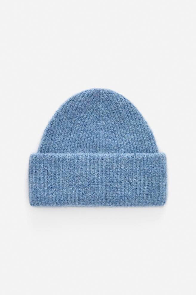 Un berretto azzurro chiaro viene presentato dalla PARTE ANTERIORE, caratterizzato da una texture a coste spesse e una forma più aderente. Un'ampia tesa viene ripiegata intorno alla sua base. - 1