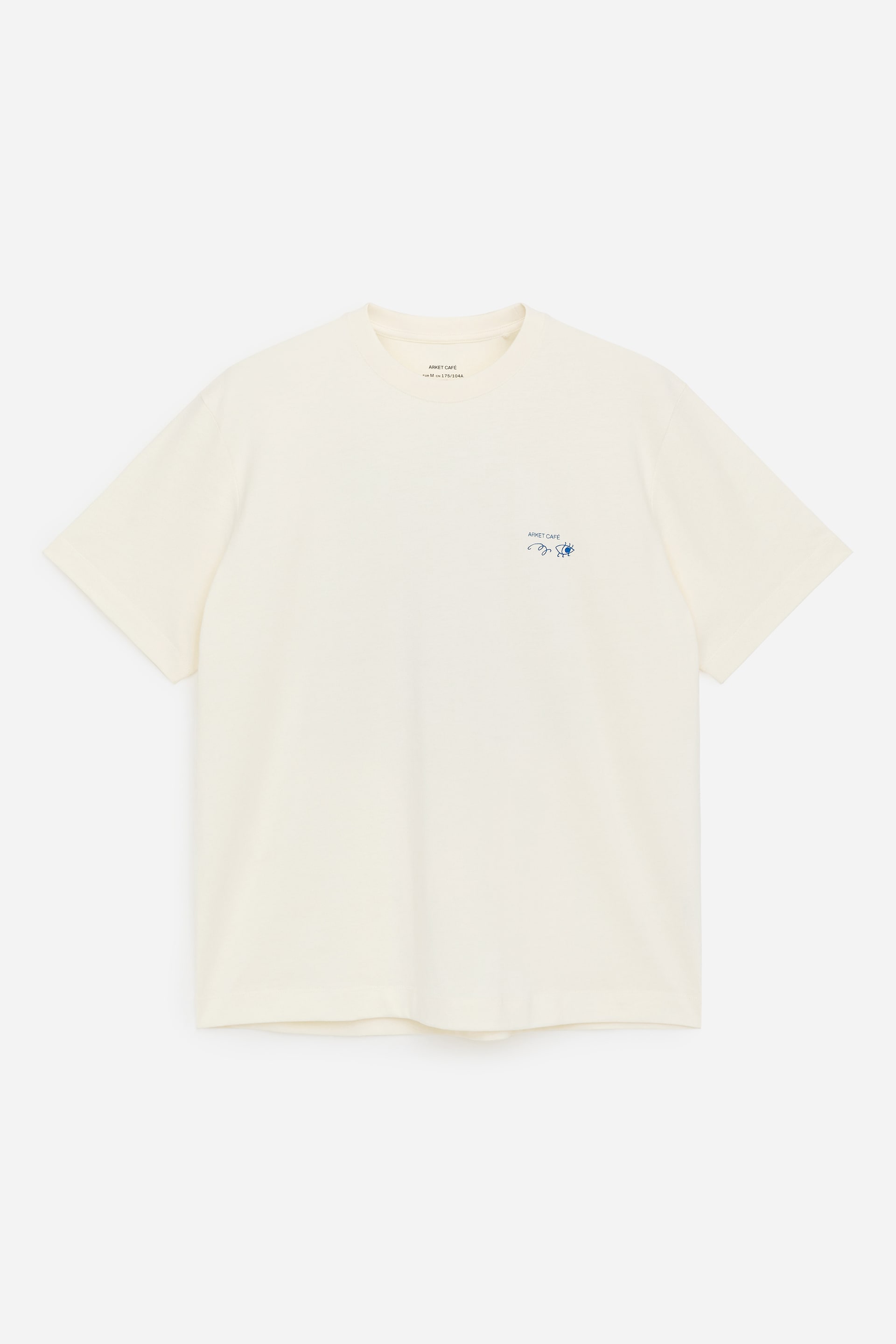 View larger image: A cream short-sleeved T-shirt is showcased from the front, featuring a crew neck and a small blue embroidered graphic on the left chest.