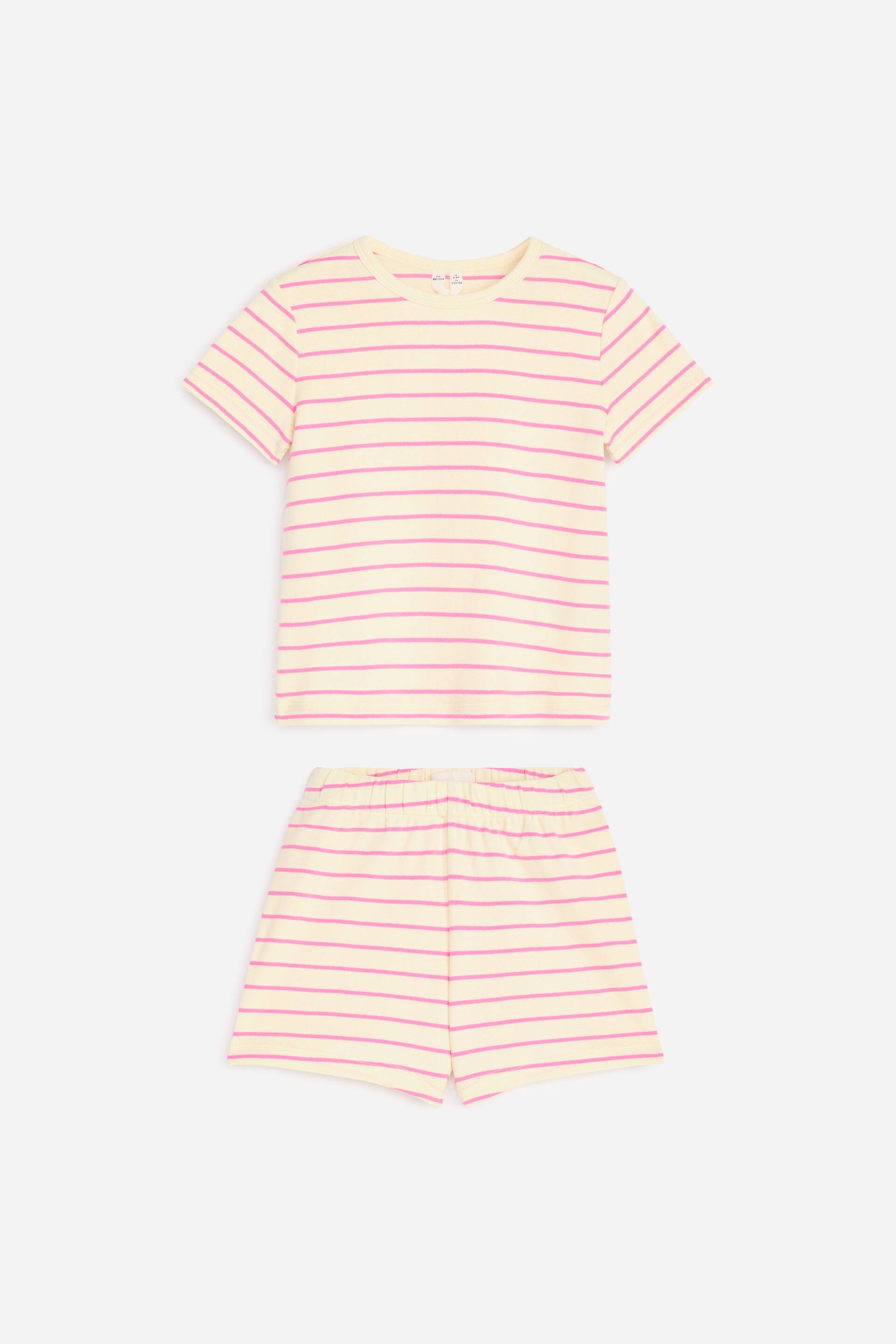 Größeres Bild ansehen: Ein Pyjama-Set wird flach präsentiert, nach vorne gerichtet, bestehend aus einem kurzärmeligen T-Shirt und einer Shorts. Beide Teile zeigen eine hellgelbe Basis mit dünnen rosa horizontalen Streifen. Das T-Shirt ist mit einem Rundhalsausschnitt gestaltet, und die Shorts verfügen über einen elastischen Bund.