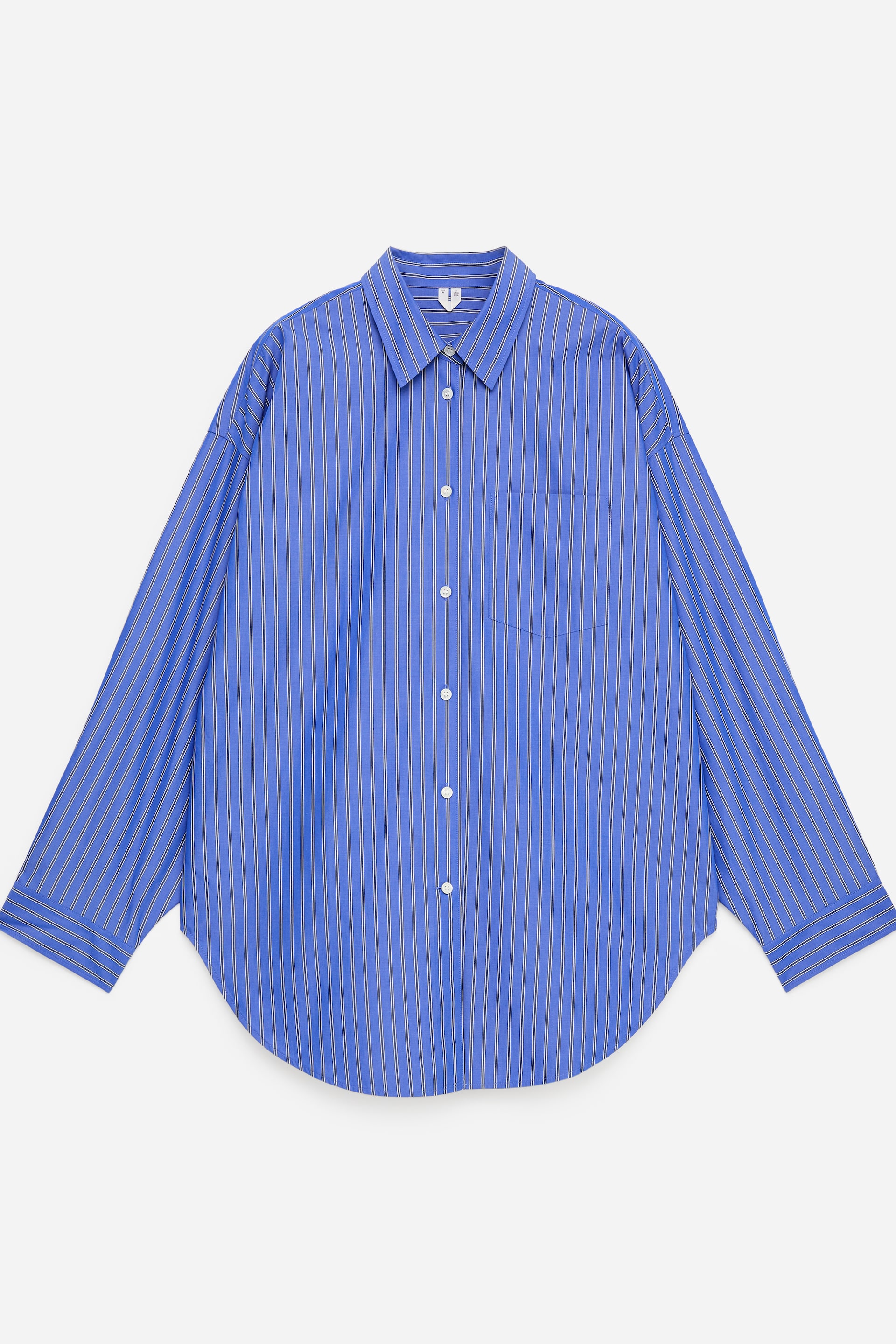 Grotere afbeelding bekijken: Dit oversized hemd wordt gepresenteerd in een vooraanzicht, met blauwe stof met dunne witte verticale strepen, een puntige kraag, een volledige knoopsluiting en een enkele borstzak aan de linkerkant. Het toont brede vleermuismouwen met knoopmanchetten en een afgeronde zoom.
