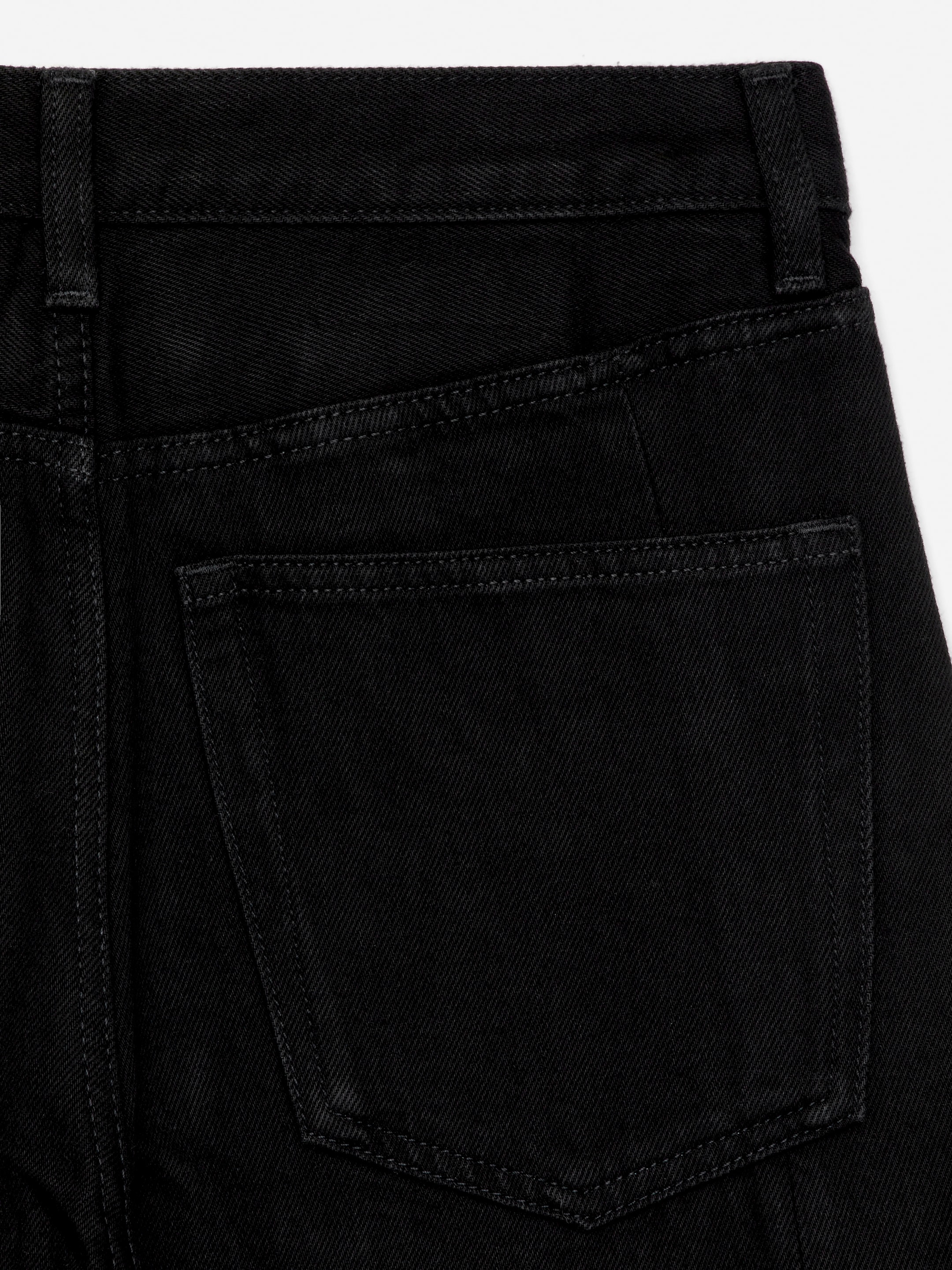 Visualizza immagine più grande: I jeans in denim nero sono mostrati da dietro, con una cintura larga, passanti per cintura e due tasche posteriori rettangolari applicate. Le cuciture a contrasto delineano le tasche e la cintura.