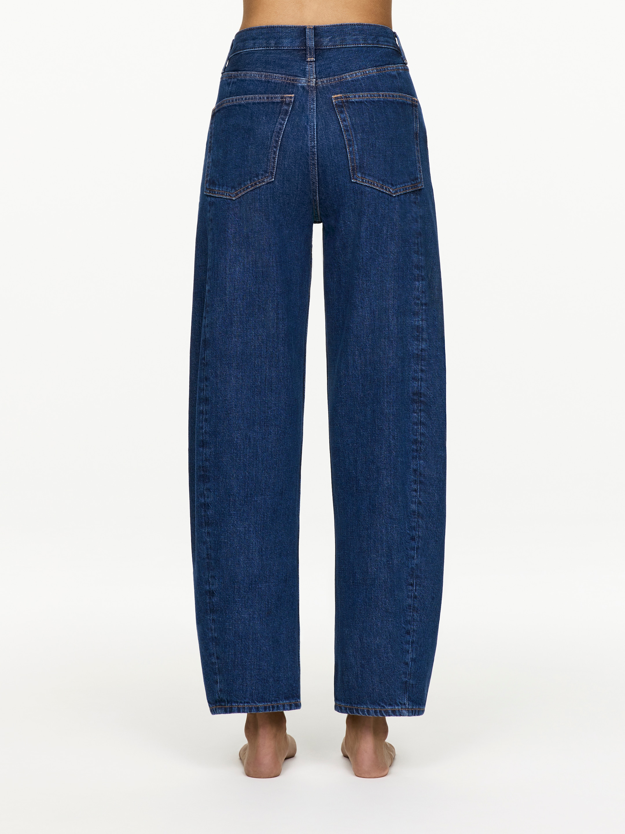 View larger image: Dark blue denim jeans are being presented from the rear view, displaying a high-waisted, wide-leg fit. They are featuring two back patch pockets, a V-shaped yoke, and belt loops on the waistband.