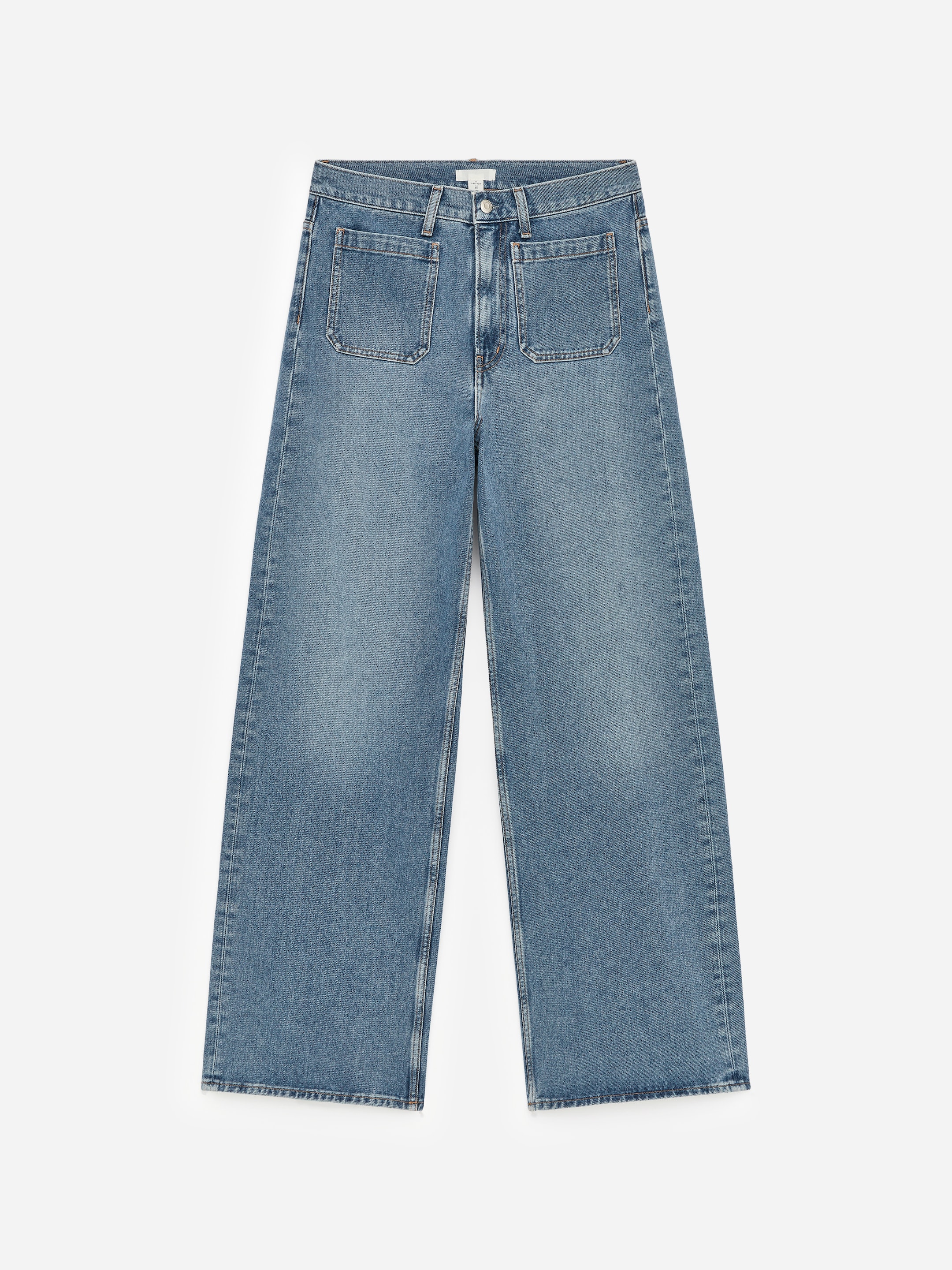 Visualizza immagine più grande: Un paio di jeans in denim blu è presentato piatto, rivolto verso il FRONTE, con una vita alta e una chiusura a zip. È progettato con una vestibilità slim sulla parte superiore della gamba, che si allarga in gambe ampie, e include grandi tasche a toppa rettangolari sul davanti.