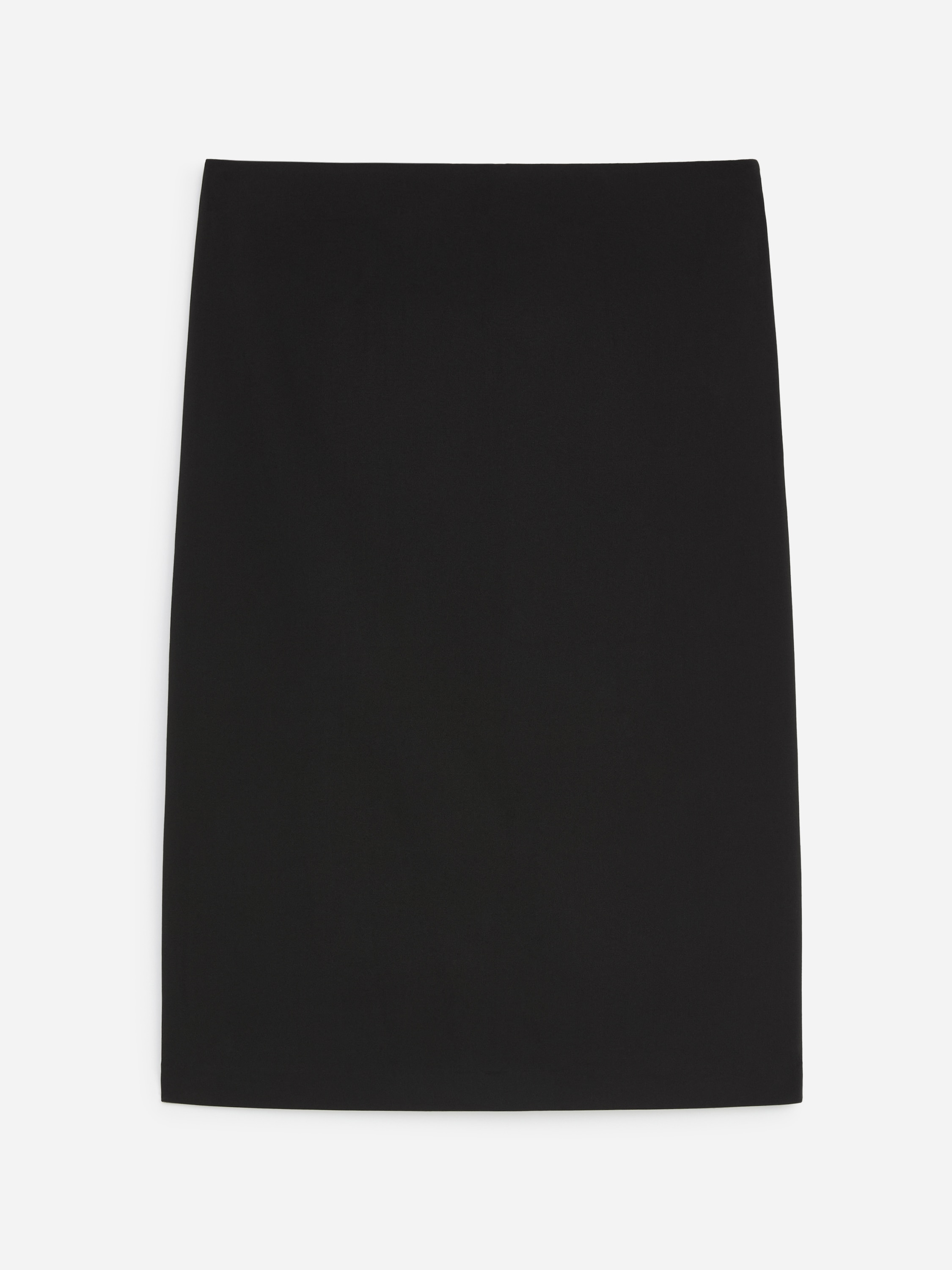 O fustÄ creion slim-fit neagrÄ, cu tiv drept, este purtatÄ de model, ajungÃ¢nd pÃ¢nÄ la genunchi. Fusta este asortatÄ cu o cÄmaÈÄ neagrÄ cu nasturi, purtatÄ lejer, neÃ®ncreÈitÄ, peste betelia fustei.