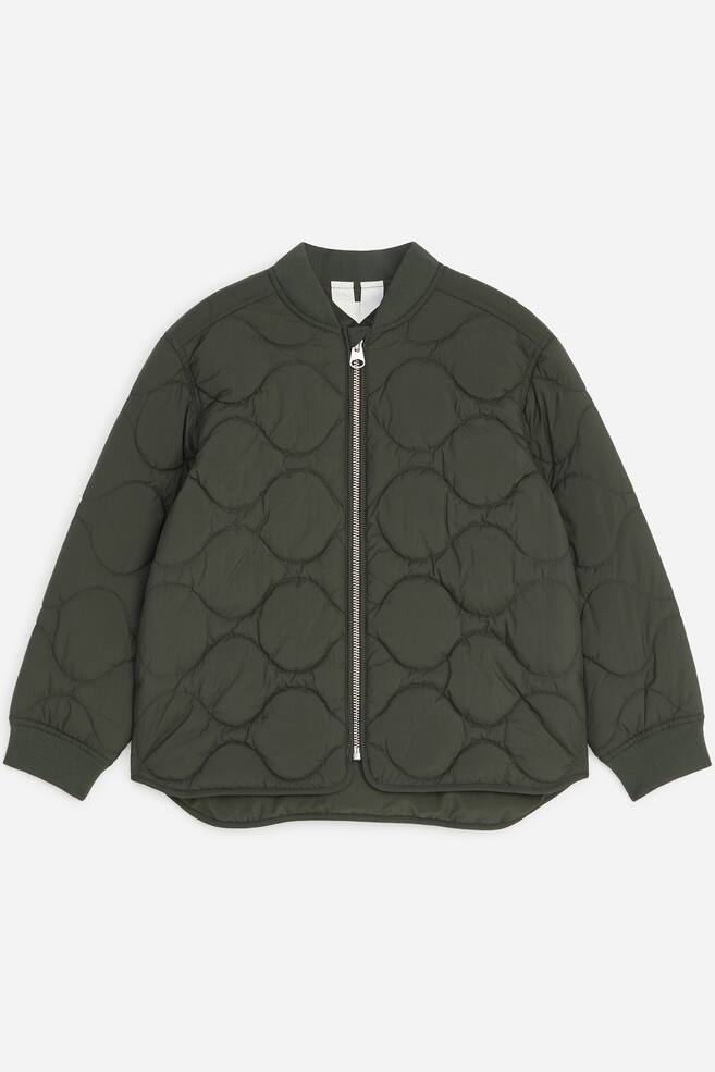 A dark green quilted lightweight jacket is depicted from the front, showcasing a wavy quilting pattern throughout its fabric. It is crafted with a ribbed bomber collar, ribbed cuffs, and a full-length silver-tone zip fastening at the front. - 1