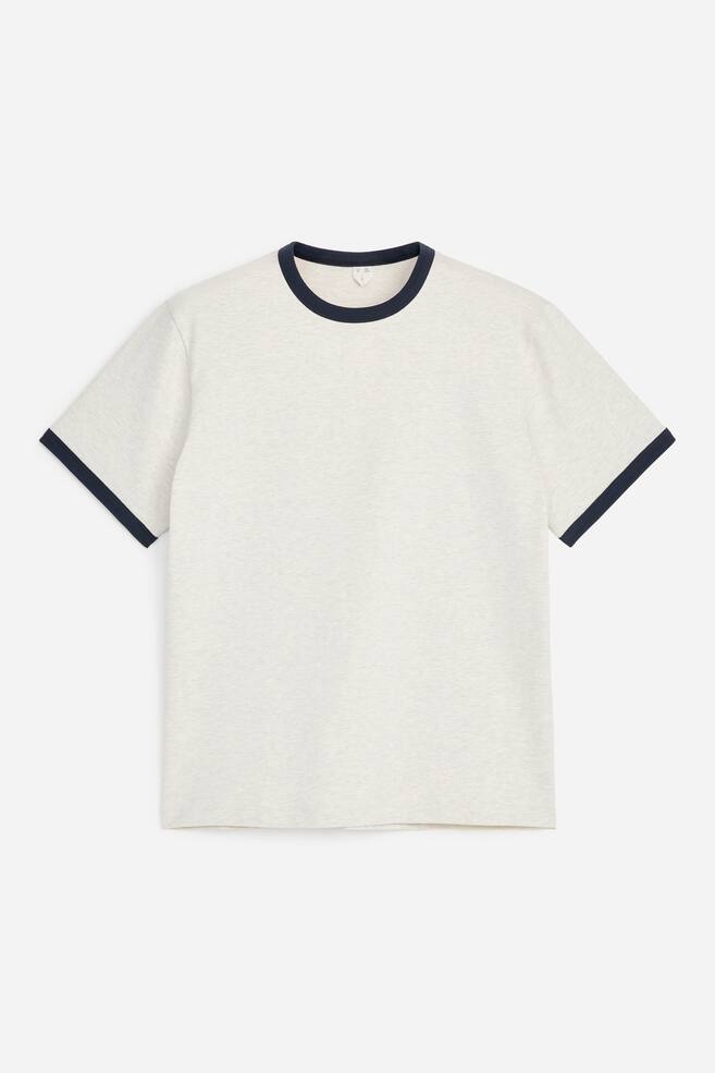 A ringer T-shirt featuring a light grey marl body with contrasting dark blue ribbed trim on its crew neck and short sleeve cuffs, facing front. - 1