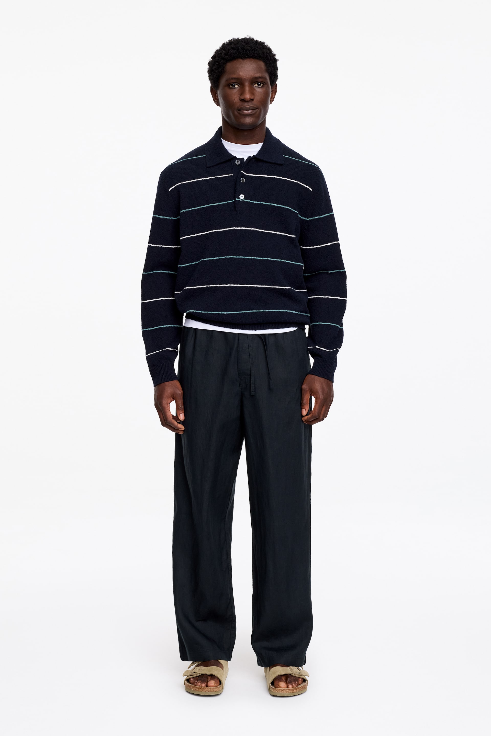 Zobraziť väčší obrázok: Tmavé ľanové nohavice s uvoľneným, širokým strihom, elastickým pásom a viditeľnou šnúrkou nosí modelka.