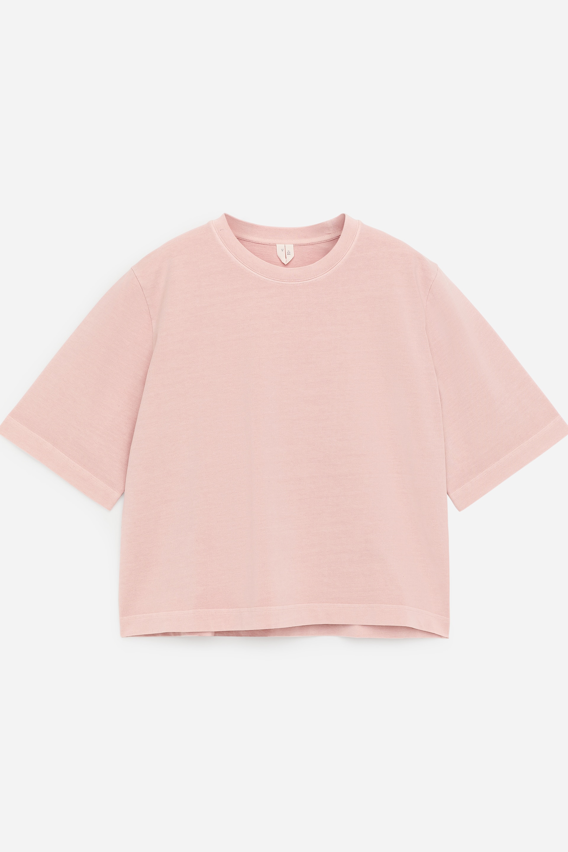 Agrandir l'image: Un t-shirt rose clair est présenté de FACE, avec un col rond et une coupe ample et carrée. Il présente des épaules tombantes, des manches courtes allongées et un ourlet légèrement raccourci, le tout confectionné dans un tissu jersey subtilement texturé.