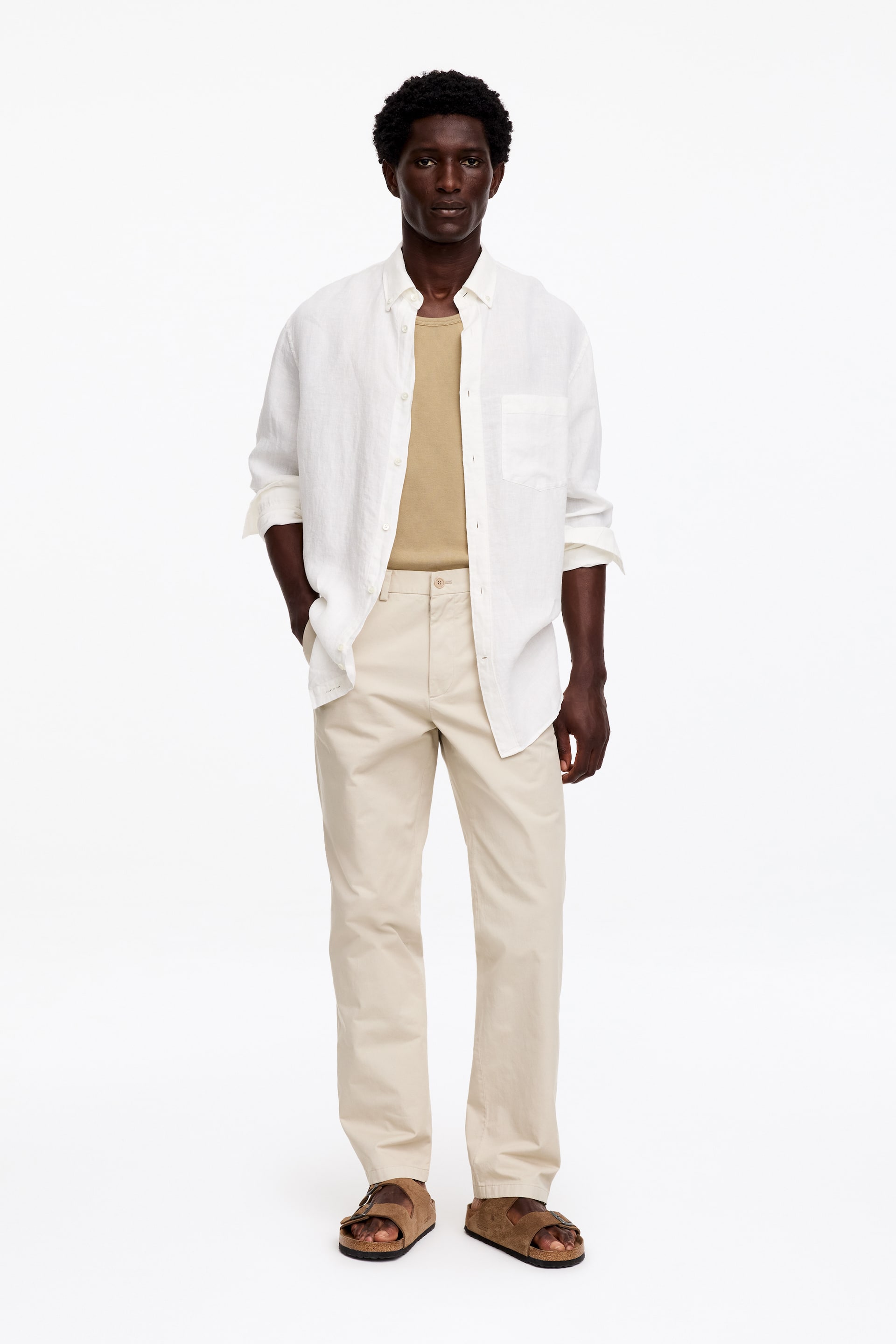 Visualizza immagine più grande: Chino in cotone beige chiaro, con vestibilità regolare e dritta, due tasche anteriori inclinate, passanti per cintura, chiusura con bottone e patta con zip, indossati dal modello.