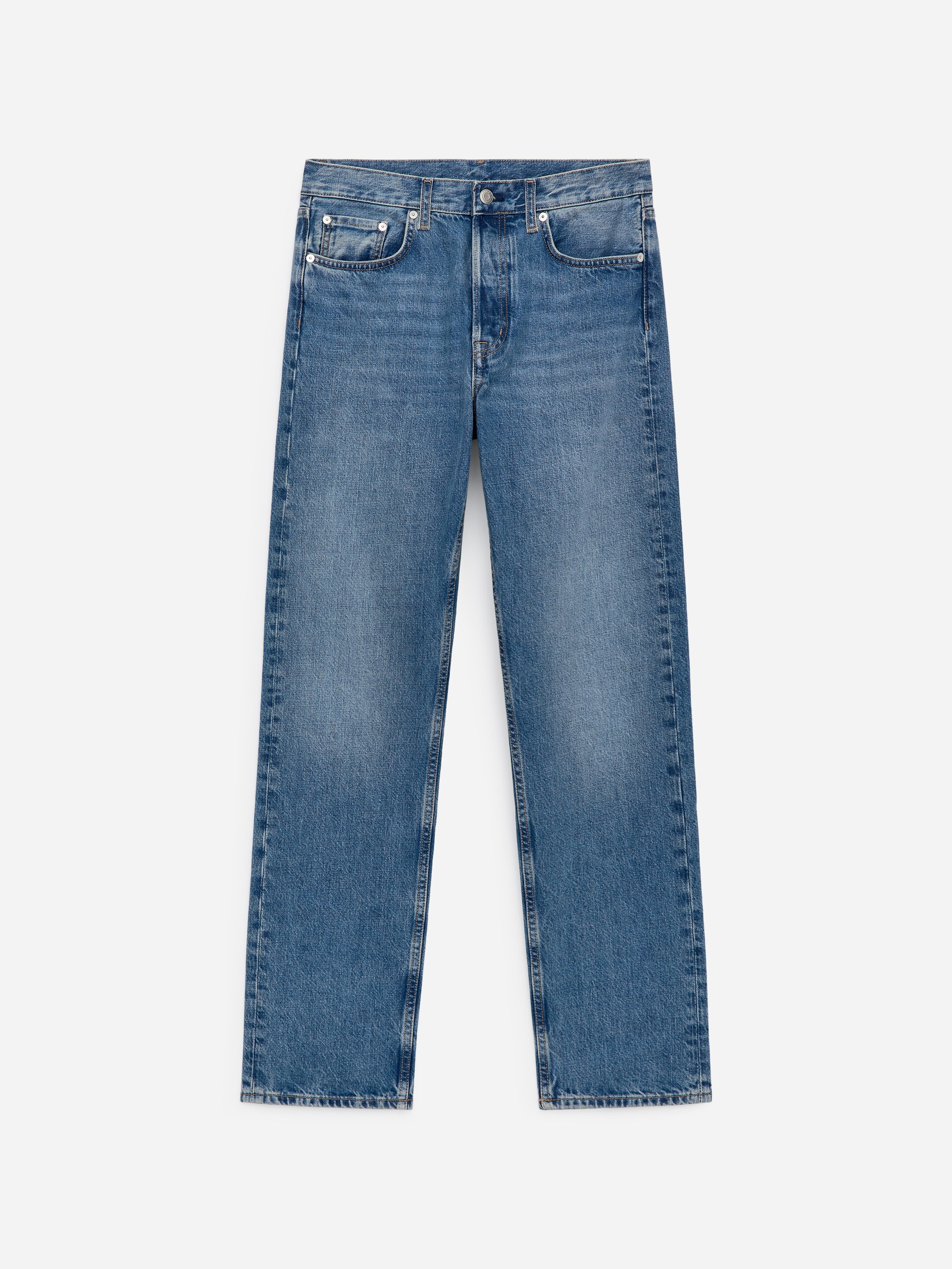 Zobacz większy obraz: Niebieskie dżinsy prezentują widok z przodu, charakteryzują się średnim stanem i zapięciem na guziki. Mają smukły, prosty krój nogawek z przednimi kieszeniami i kieszonką na monety.