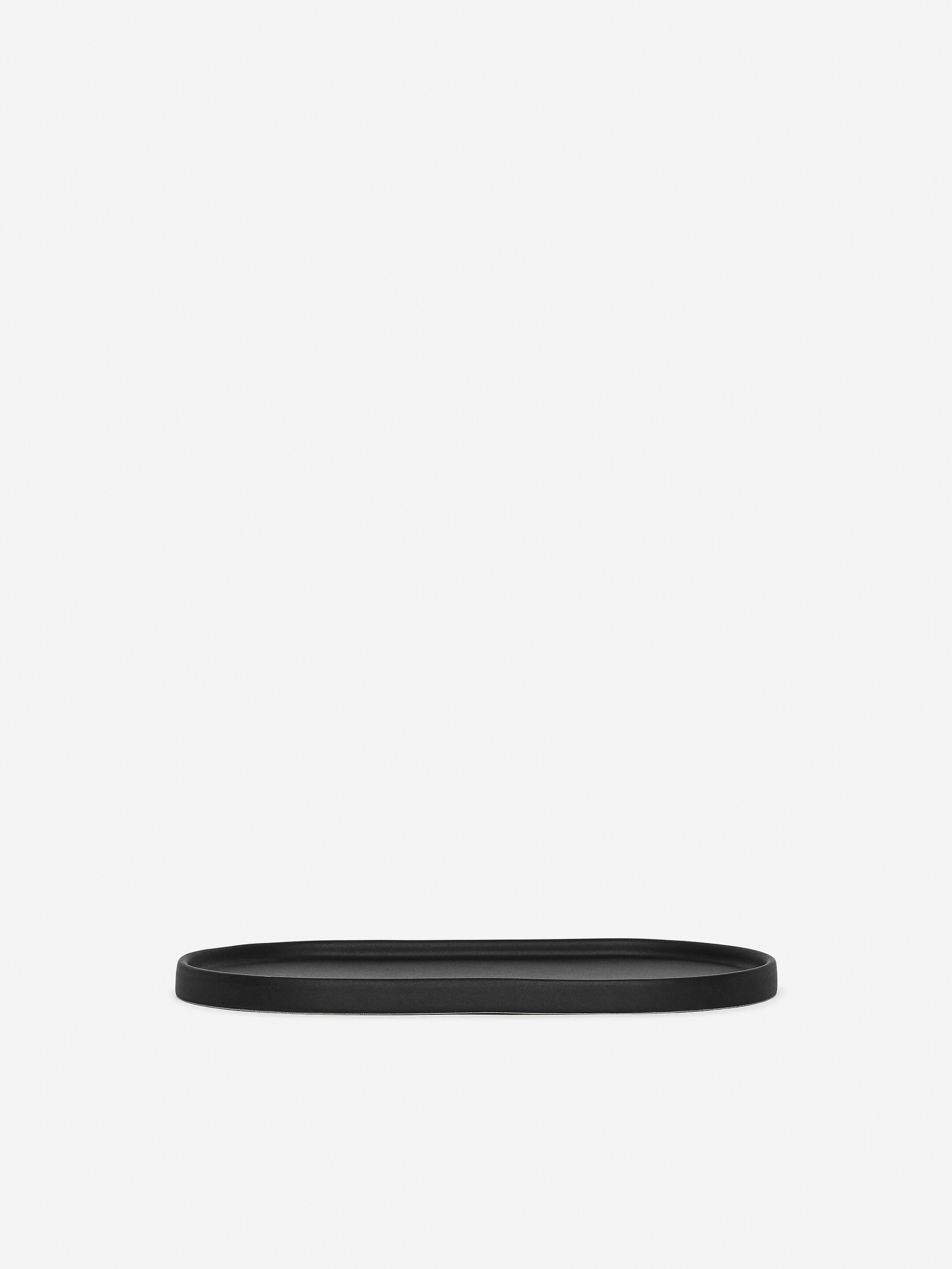 Ver imagem maior: Um prato oval preto e alongado está a ser apresentado de frente, com uma superfície mate e vidrada e uma borda ligeiramente elevada.