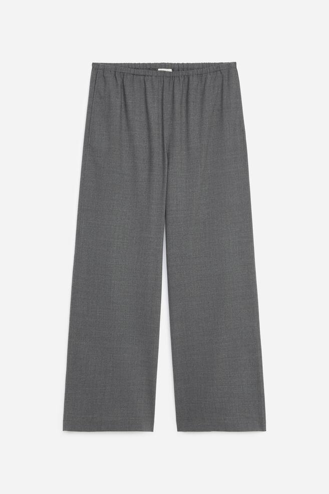 Diese grauen Wide-Leg-Hosen sind von vorne abgebildet und zeigen einen gerafften elastischen Bund, seitliche Eingrifftaschen und eine lockere, gerade geschnittene Silhouette. - 1