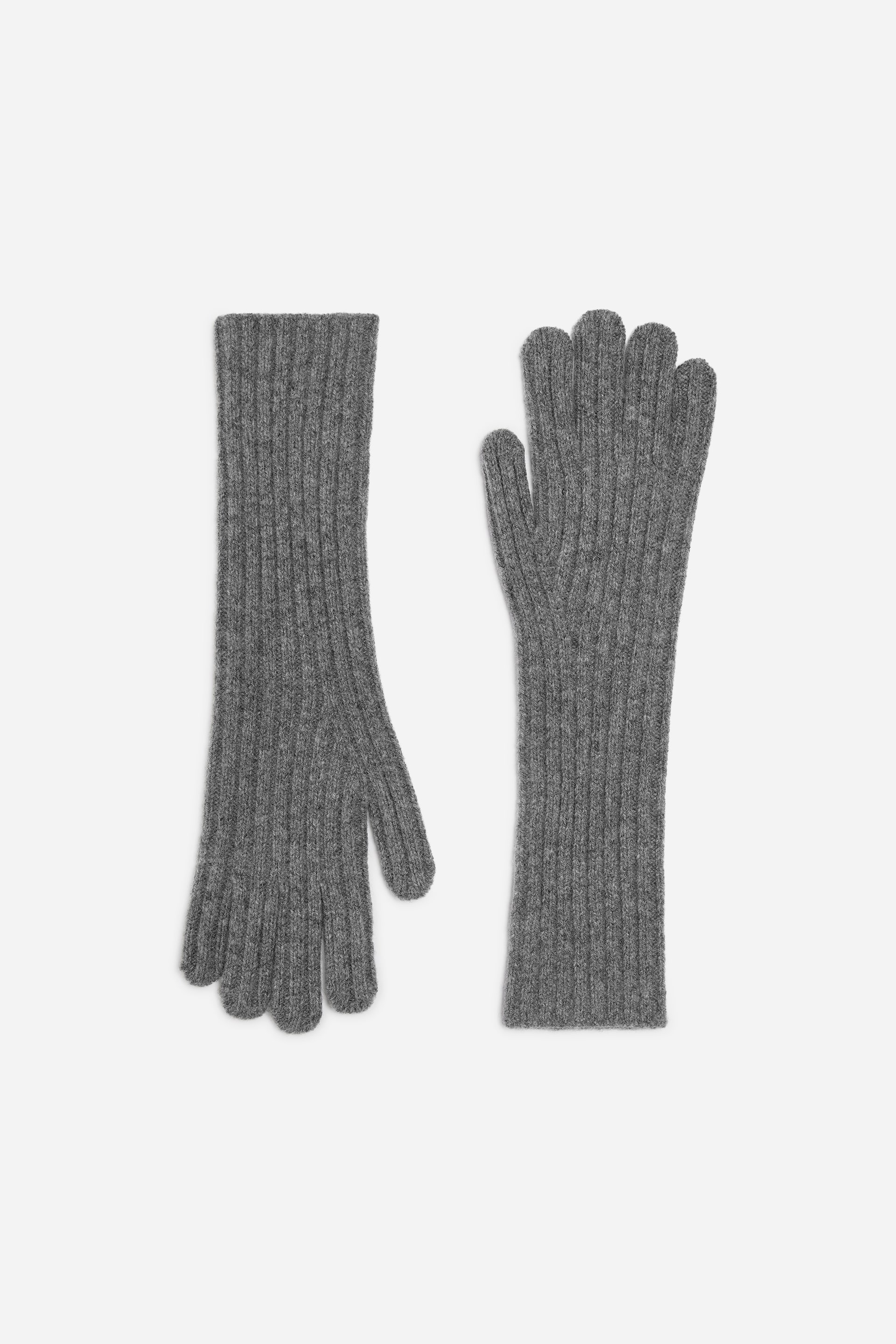 Größeres Bild ansehen: Ein Paar graue, gestrickte Wollhandschuhe liegt flach und zeigt eine langgestreckte Silhouette mit feiner Rippstruktur und verlängerten Bündchen. Die Handschuhe sind frontal ausgerichtet, wobei einer nach oben und der andere nach unten zeigt, um das Gesamtdesign zu präsentieren.