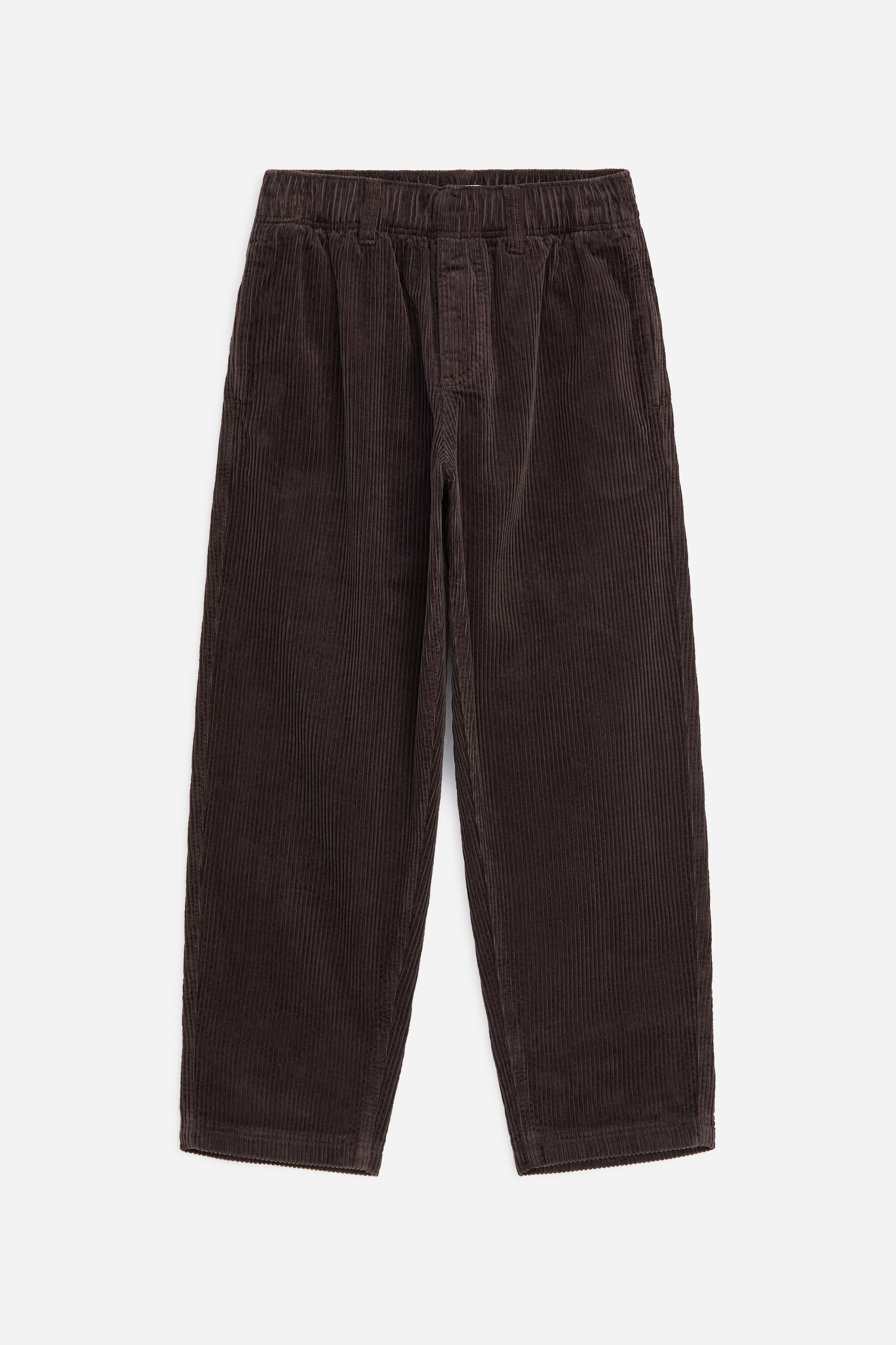View larger image: Brown corduroy trousers are facing forward, featuring an elasticated waistband with subtle pleats below it. They are displaying a wide-leg structure with visible vertical wales.