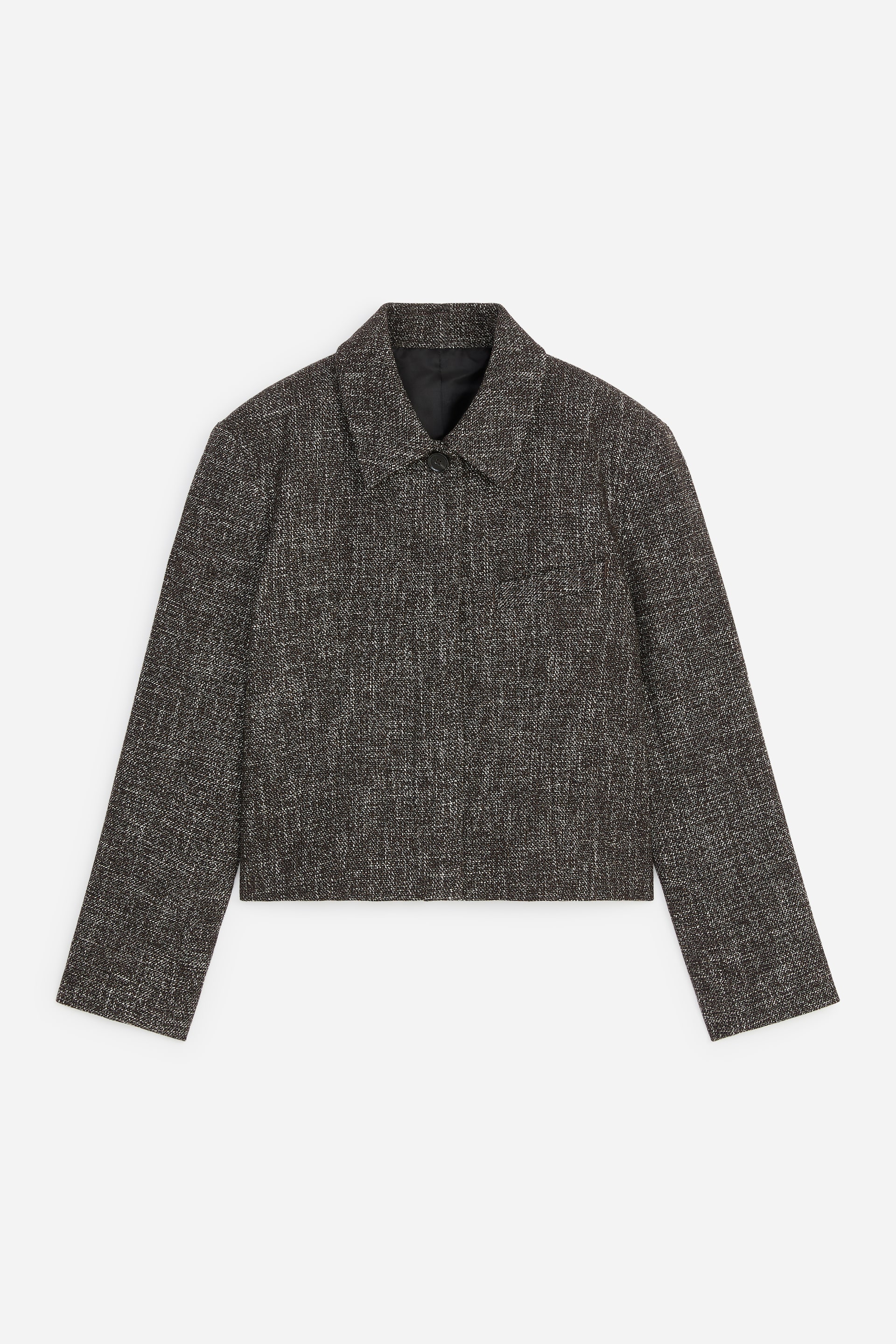 Agrandir l'image: Une veste courte, vue de face, est réalisée dans un tissu tissé moucheté brun foncé et blanc. Elle présente un col pointu, une fermeture à un seul bouton noir au niveau du cou, des manches longues et un ourlet droit, avec une discrète poche passepoilée horizontale visible sur le côté droit de la personne qui la porte.